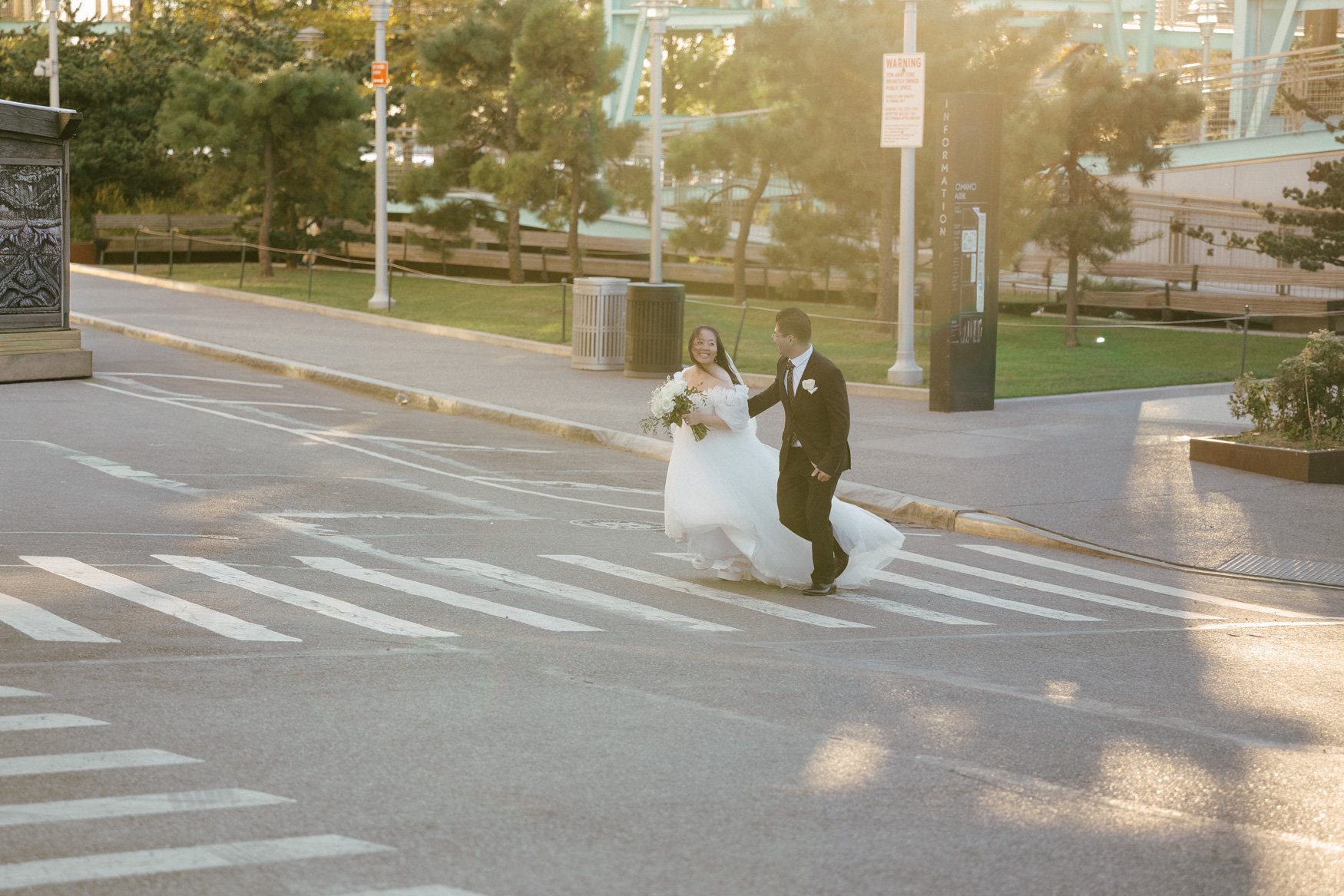 documentary wedding portrait of bride and groom running down the streets of brooklyn