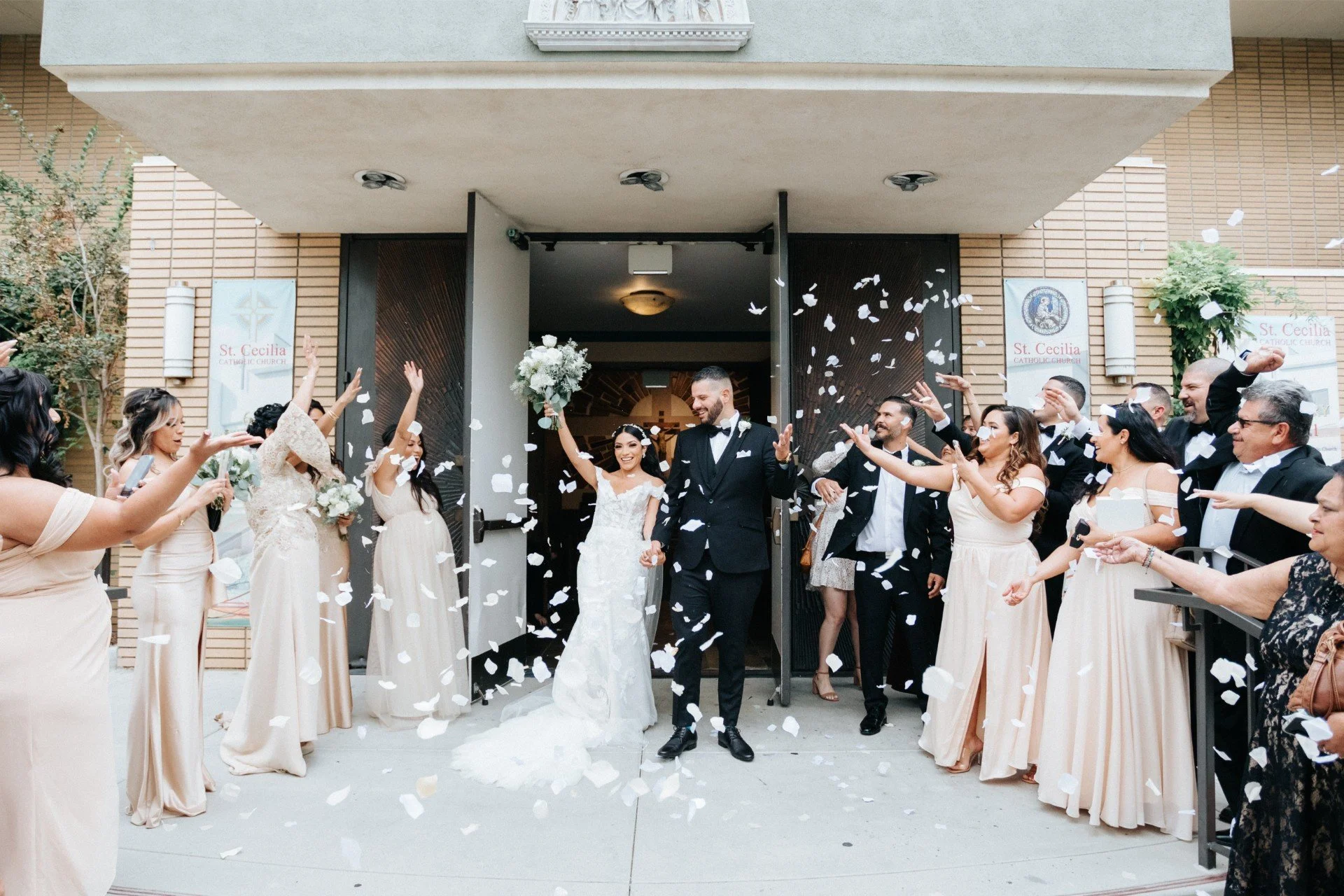 candid wedding photography of Bride and Groom showered with flower petals as they exit the church, los angeles and destination wedding photographer by evening