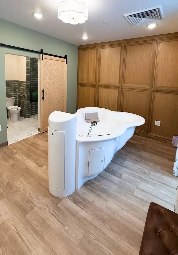 Spacious birth suite with a deep water birth tub, birthing balls, and comfortable bed at Cache Valley Birth Center
