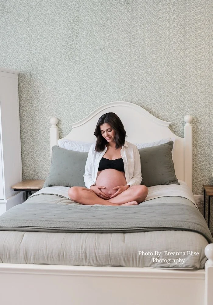 Pregnant woman cradling her belly in a cozy birth suite for pregnancy care at Cache Valley Birth Center in Logan, Utah
