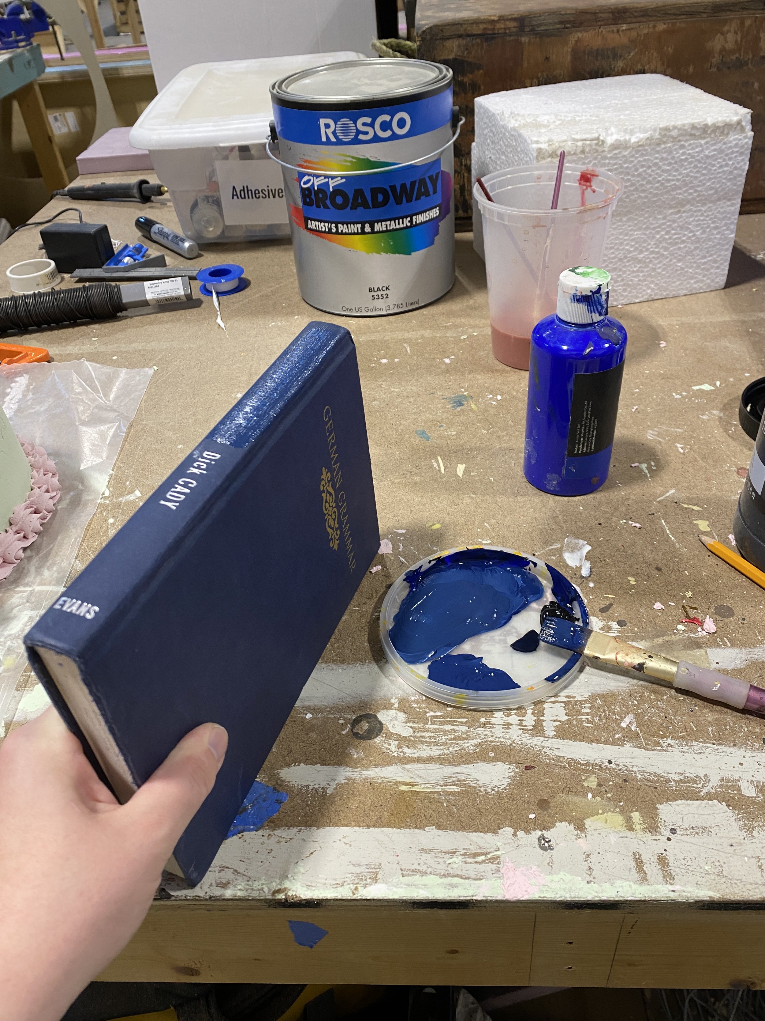 I mixed together paint to cover up the lettering on the spines of the books while also matching the colors used for book binding in 1860's- 1890's Europe