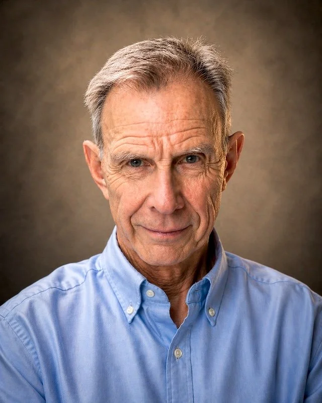 A photograph of author John E. Rees