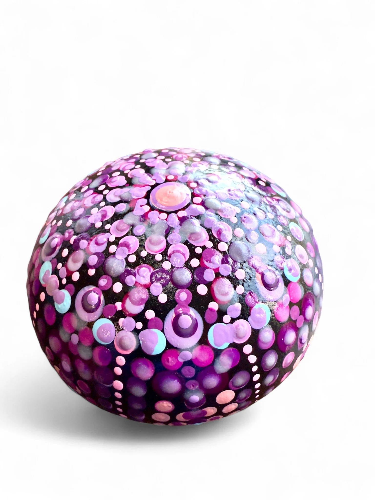 Painted spherical object with pink, purple, and blue bubble patterns on a white background.
