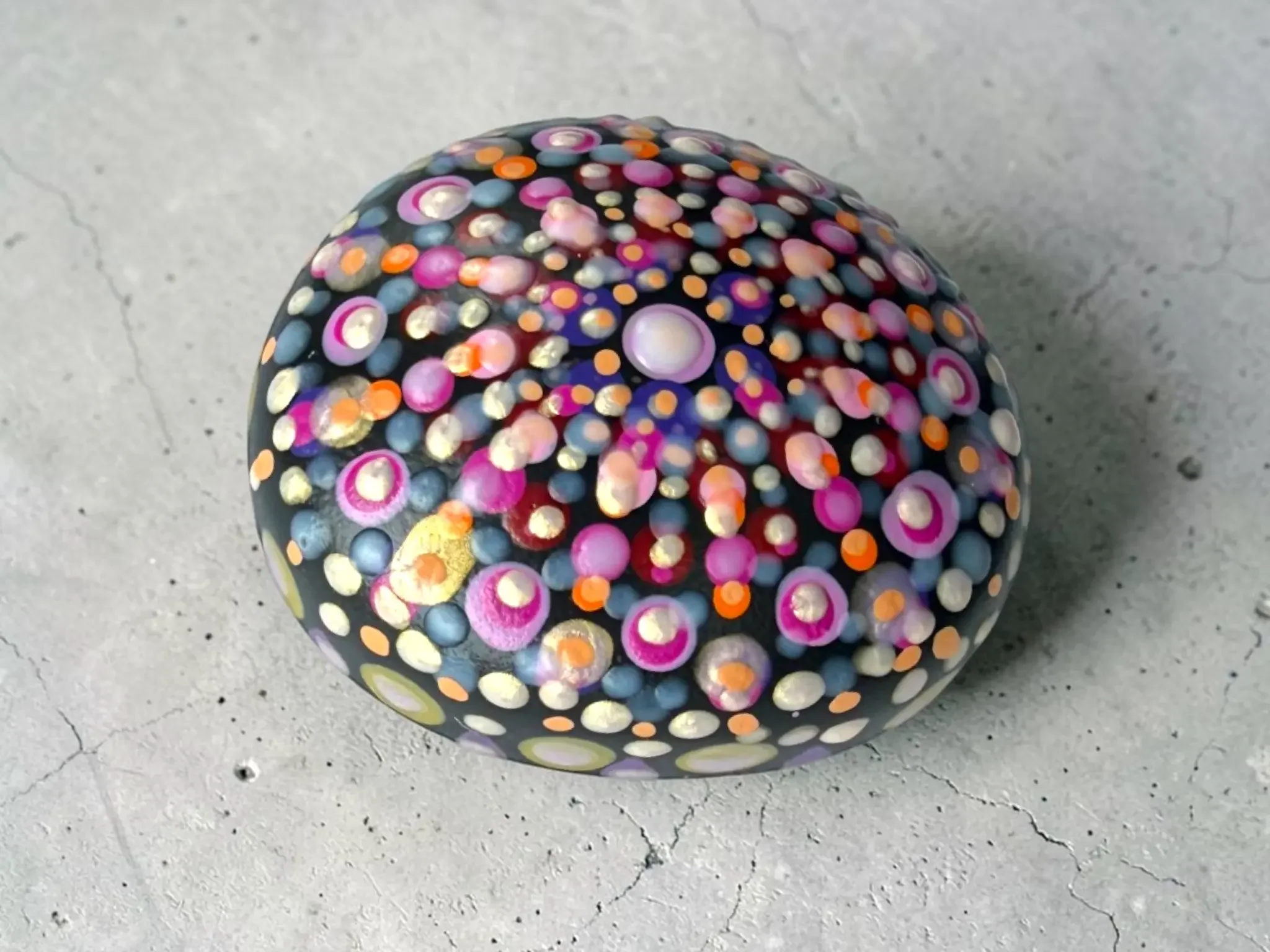 Small mandala stone by Color Cult featuring vibrant dot mandala artwork that glows in the dark.