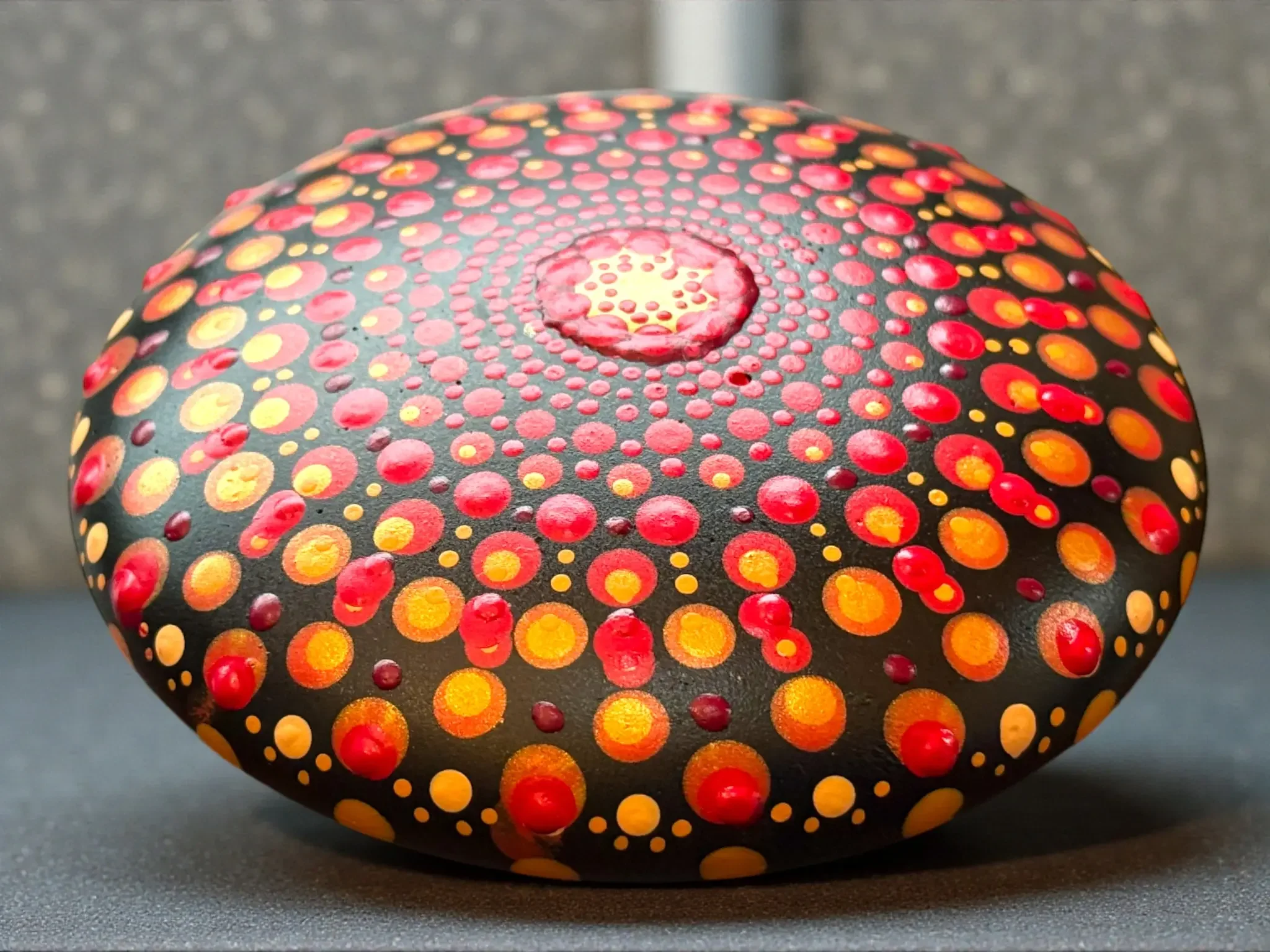Medium Mandala Stone by Color Cult in reds and yellow and gold dot mandala design.