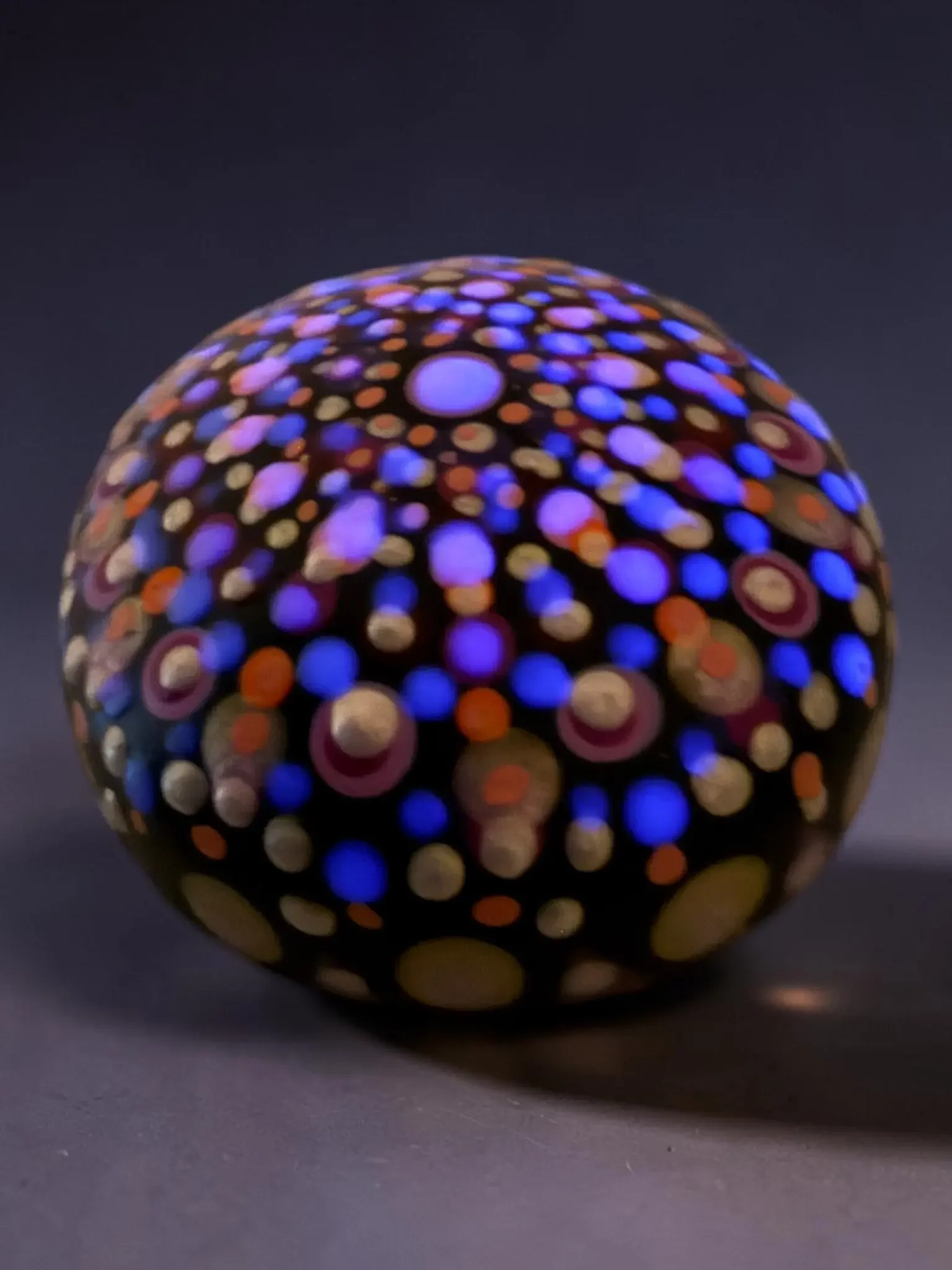 Small mandala stone by Color Cult featuring vibrant dot mandala artwork that glows in the dark.