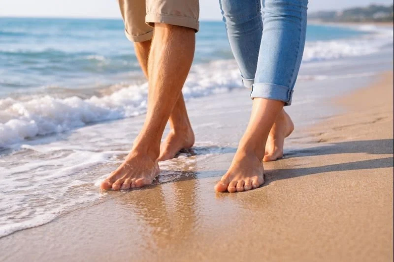 Close-up of feet walking on the beach symbolizing pain-free movement and foot health.