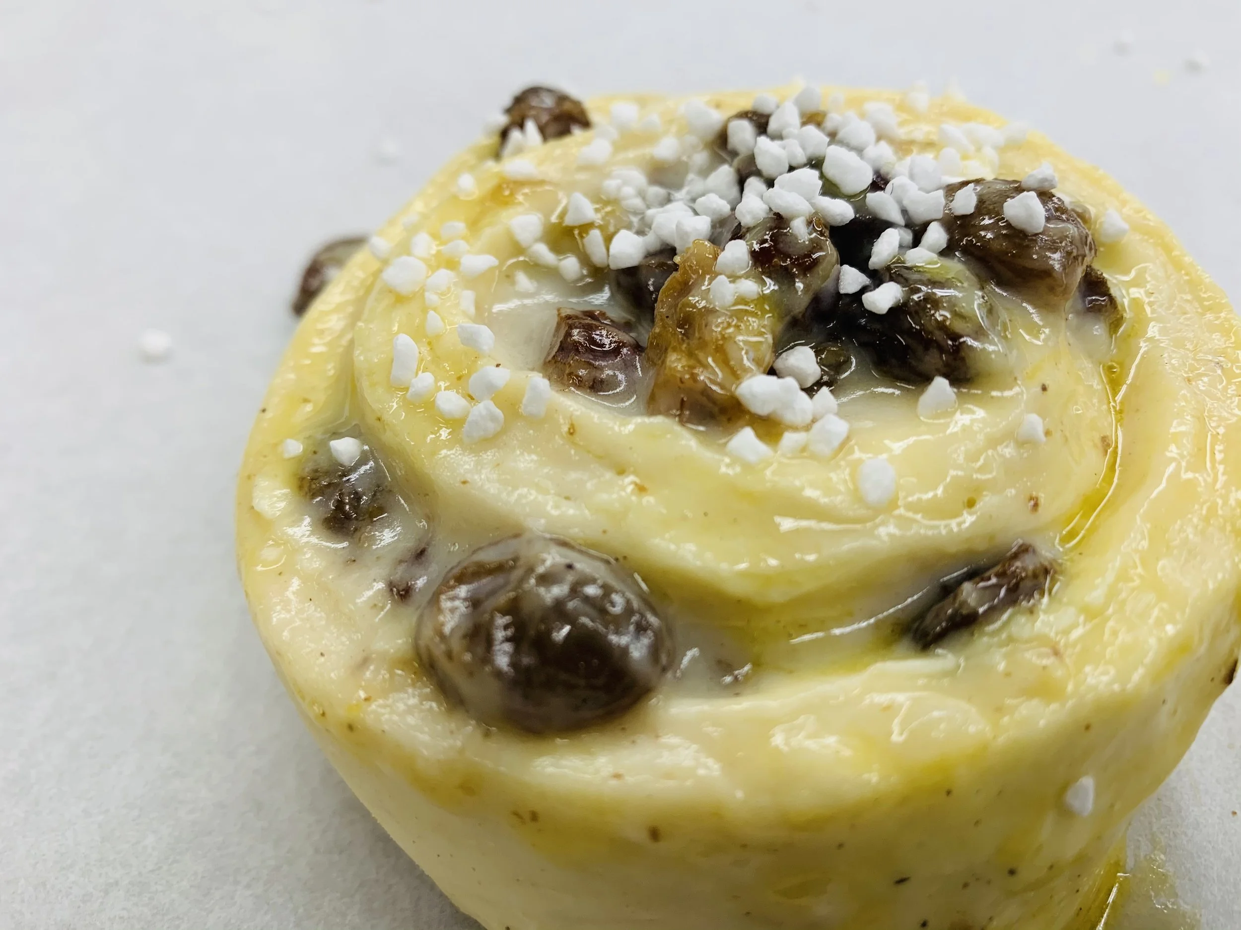 Close-up of a frozen dessert with chunks of chocolate and white sprinkles on top.