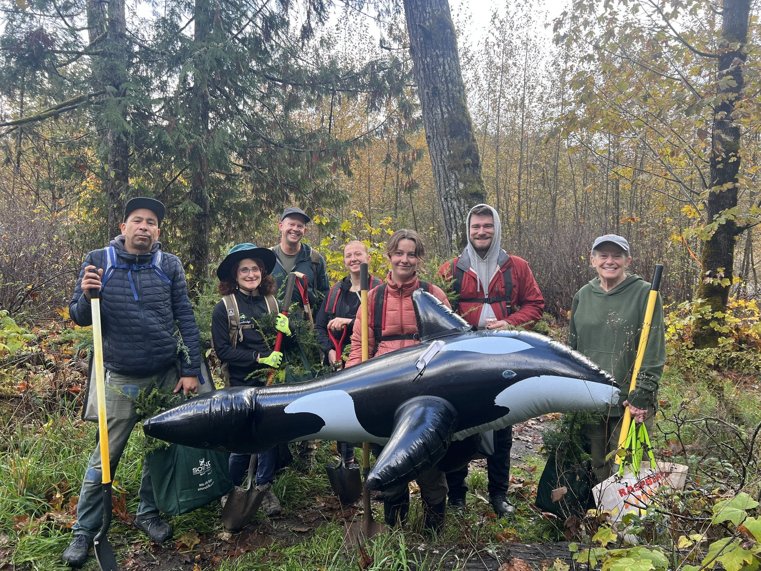 Another group of smiling volunteers with the inflatable orca