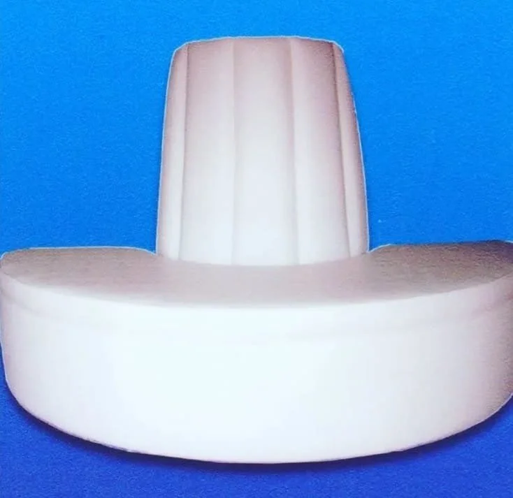 A white padded chair with a tall backrest and rounded seat, set against a blue background.