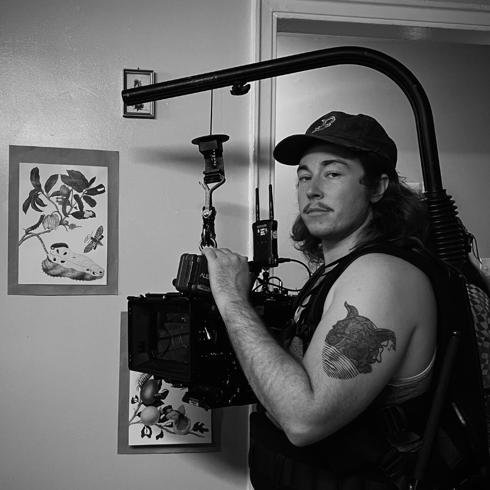 Young man with a beard working with a large professional camera on a rig.