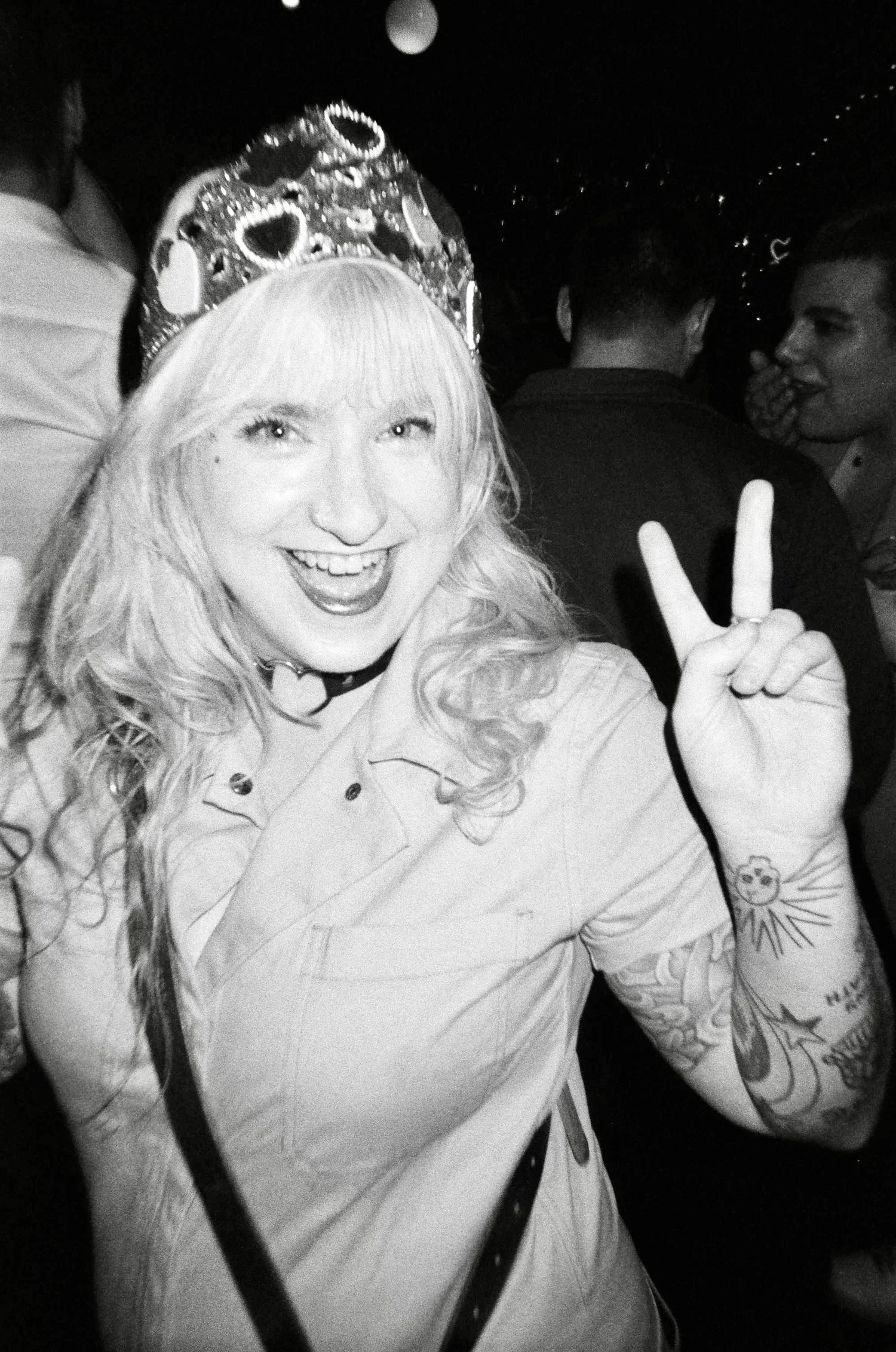 Black and white portrait of a woman with wavy hair wearing a studded jacket.
