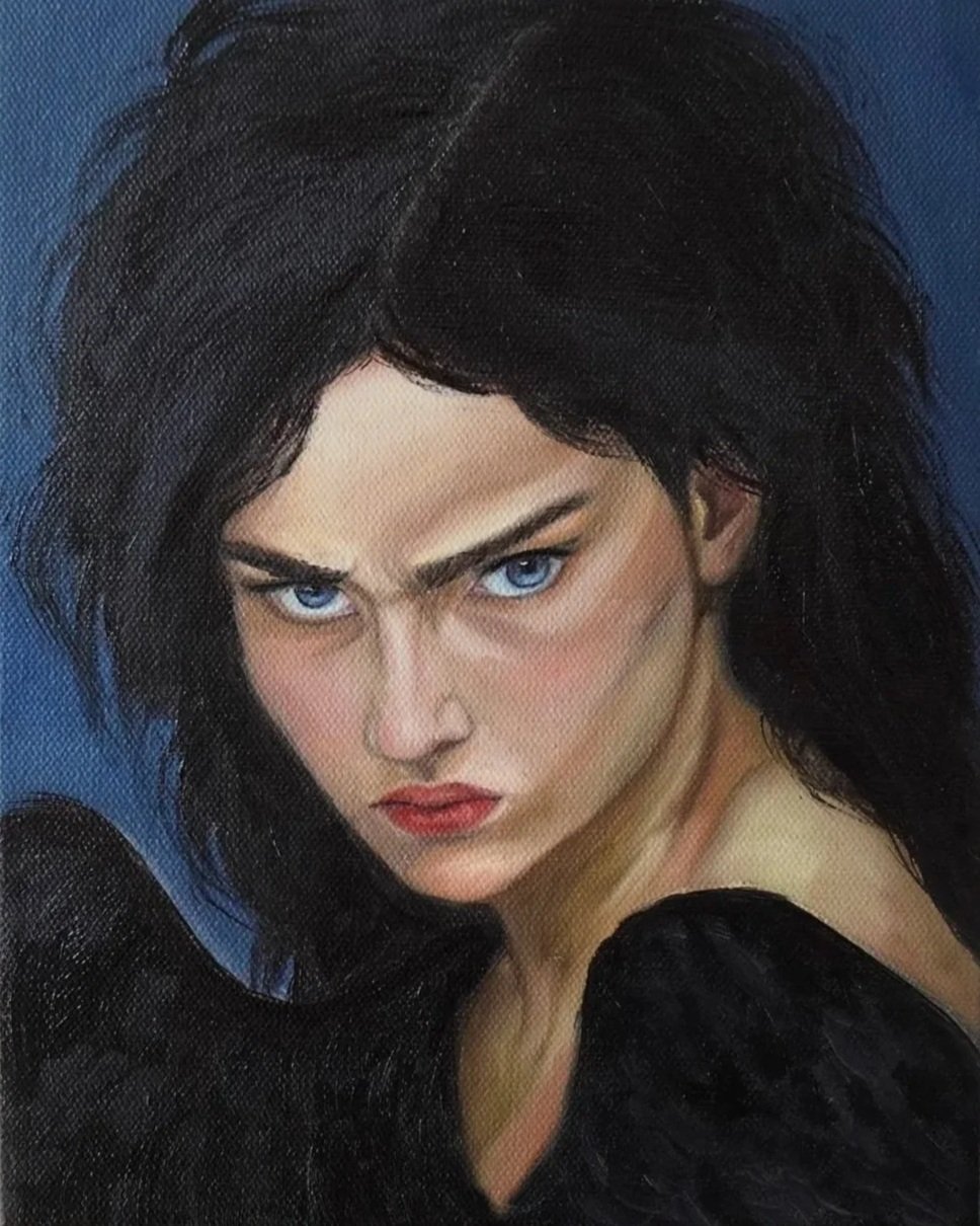 A portrait of a woman with intense blue eyes and dark, tousled hair, wearing a black top, against a blue background.