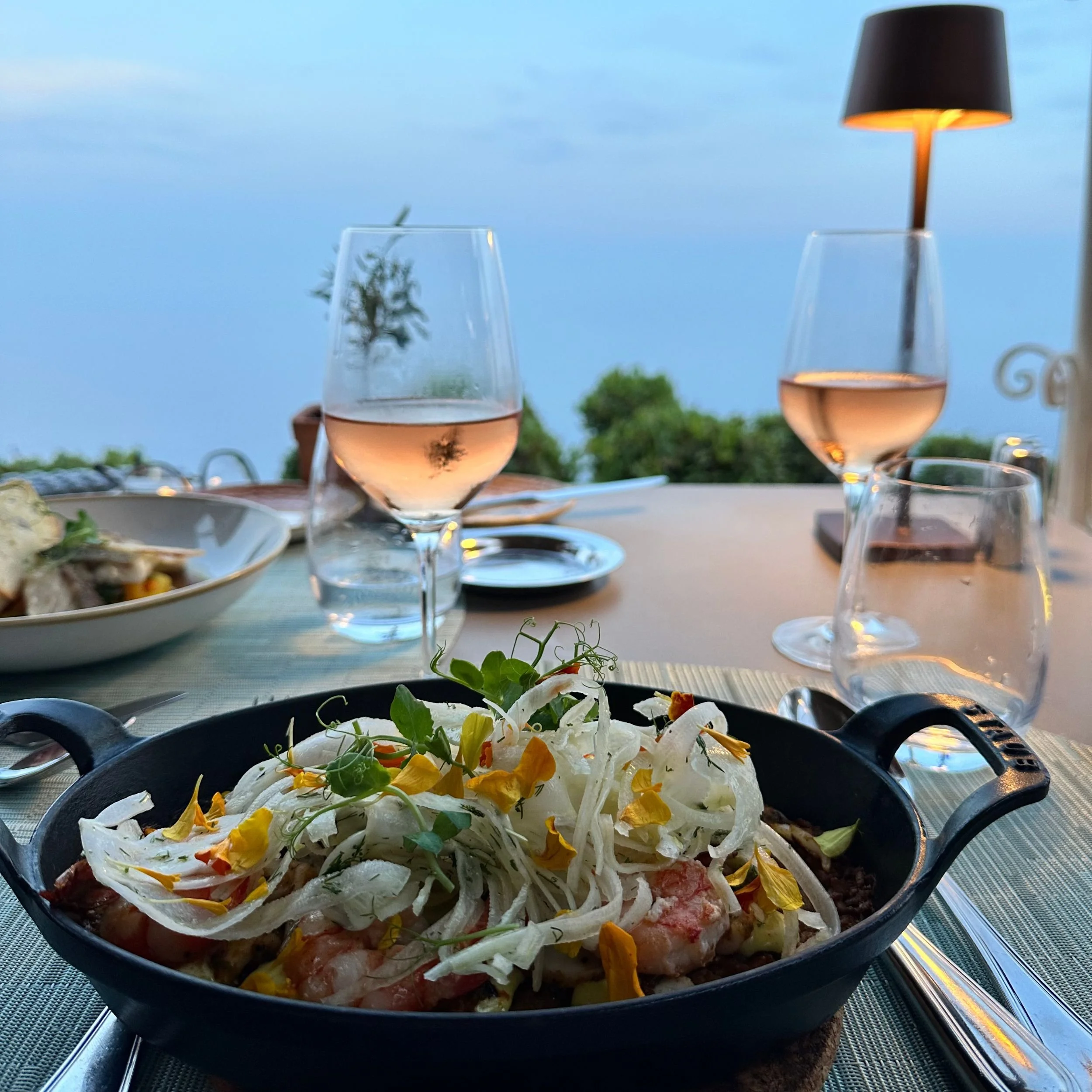 A delicate starter of citrus-cured fish with rosé wine at Les Remparts restaurant, overlooking the Riviera.