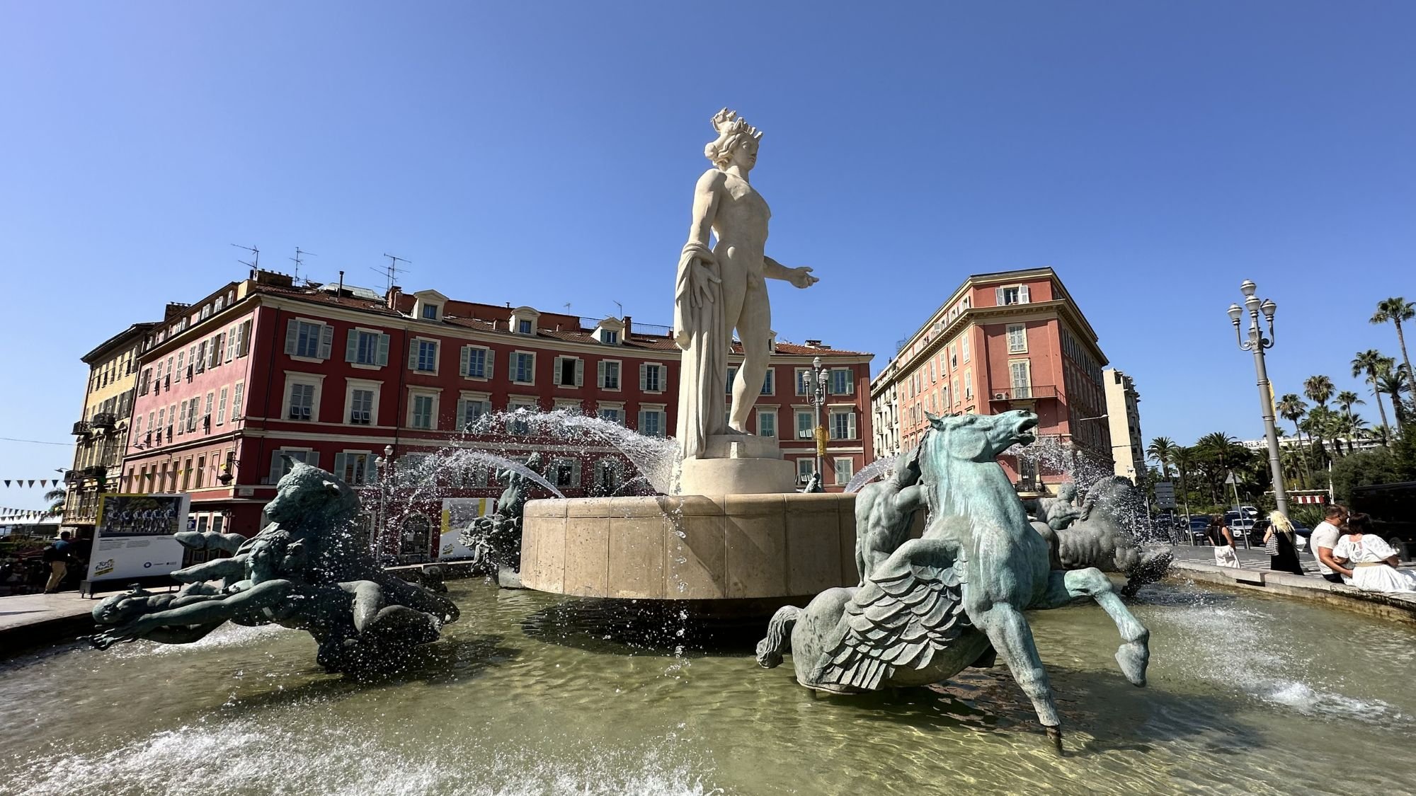  The striking Apollo statue at the Fontaine du Soleil water fountain in Place Masséna under a clear blue sky in Nice France. 