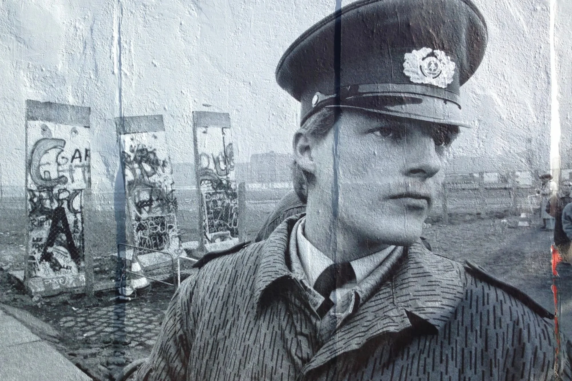 A mural depicting a border guard in uniform against the backdrop of the Berlin Wall and the former death strip.