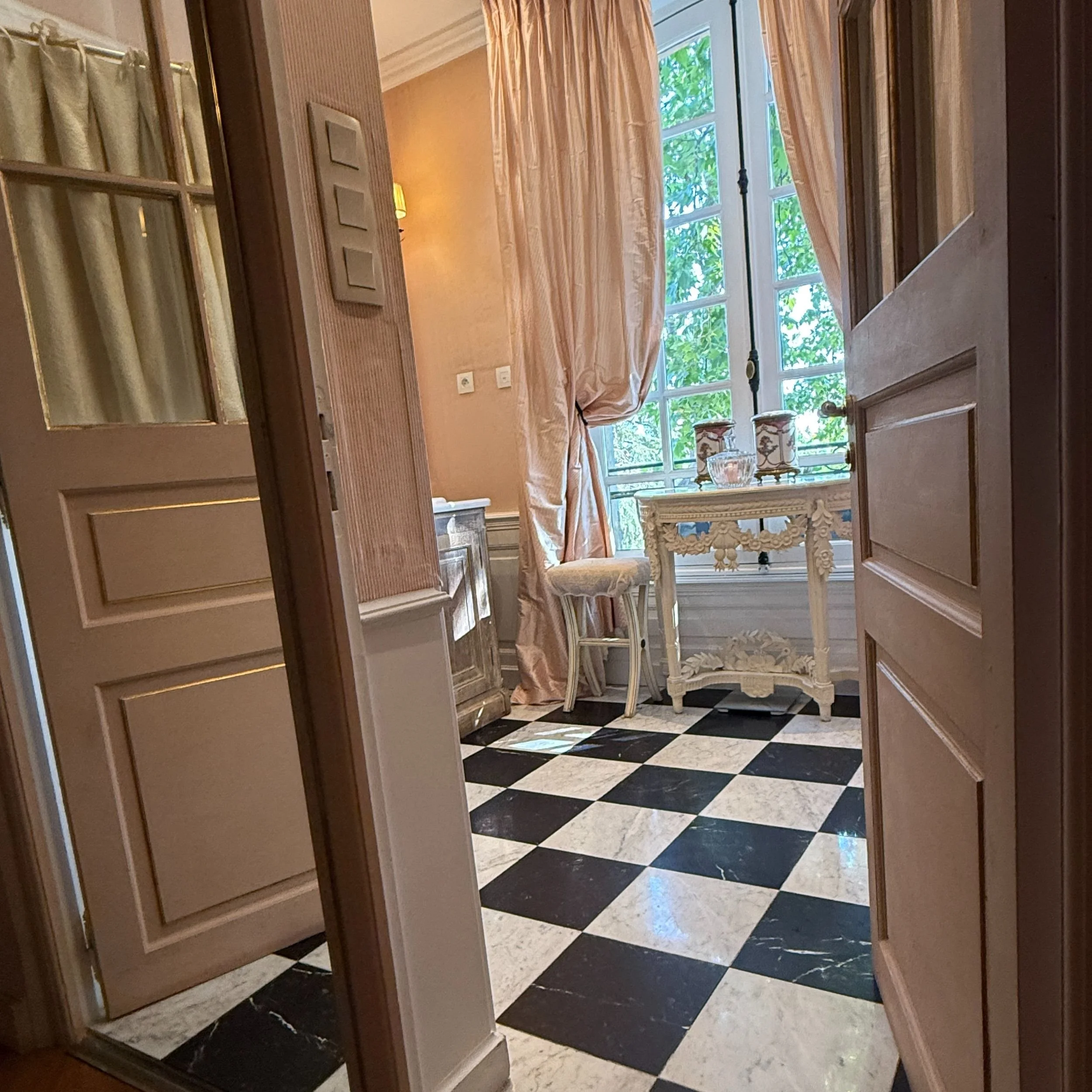 Bathroom interior at Villa Gallici in Aix-en-Provence with black and white tiled floor and dressing table