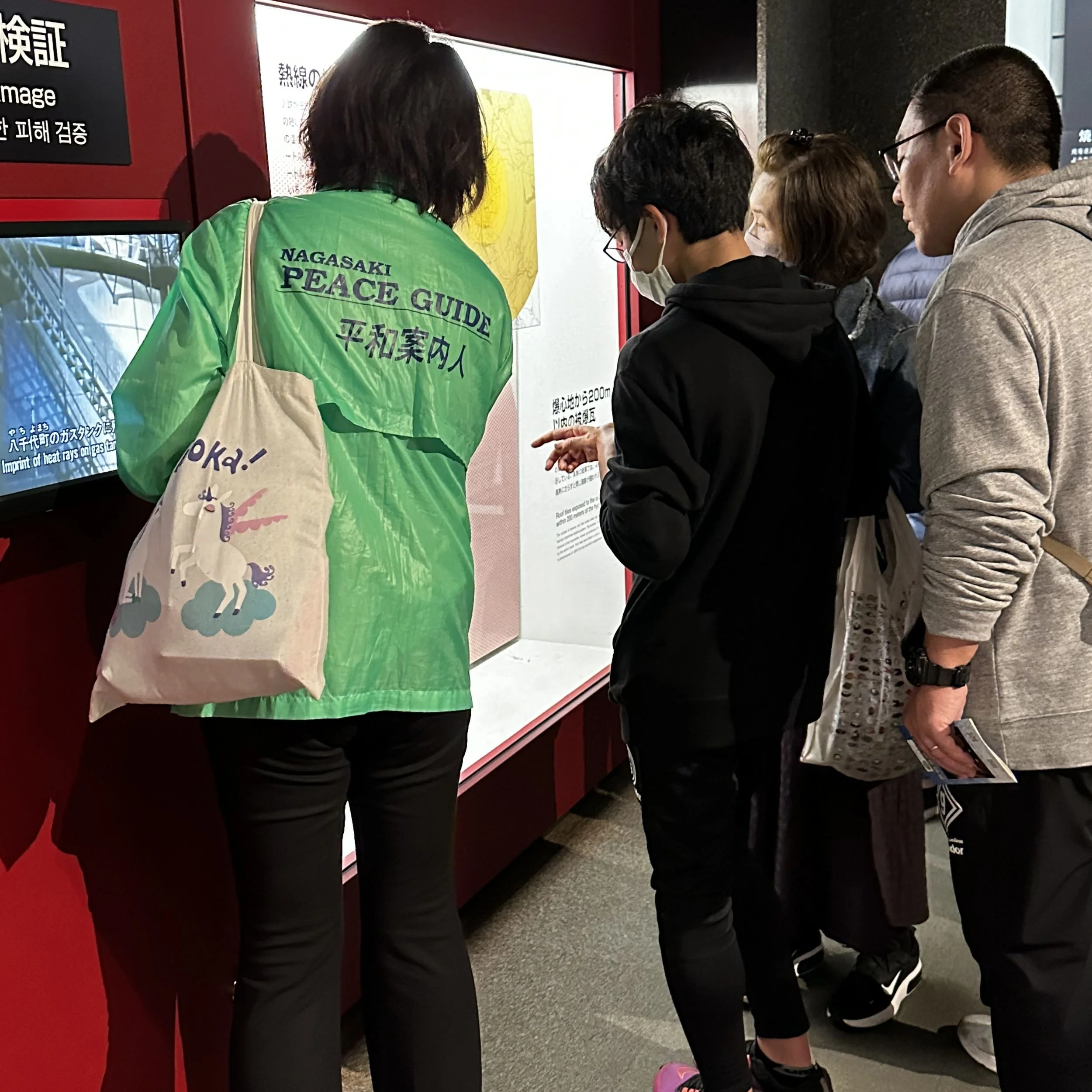 Nagasaki Peace Guide explaining museum exhibit to visitors at the Atomic Bomb Museum