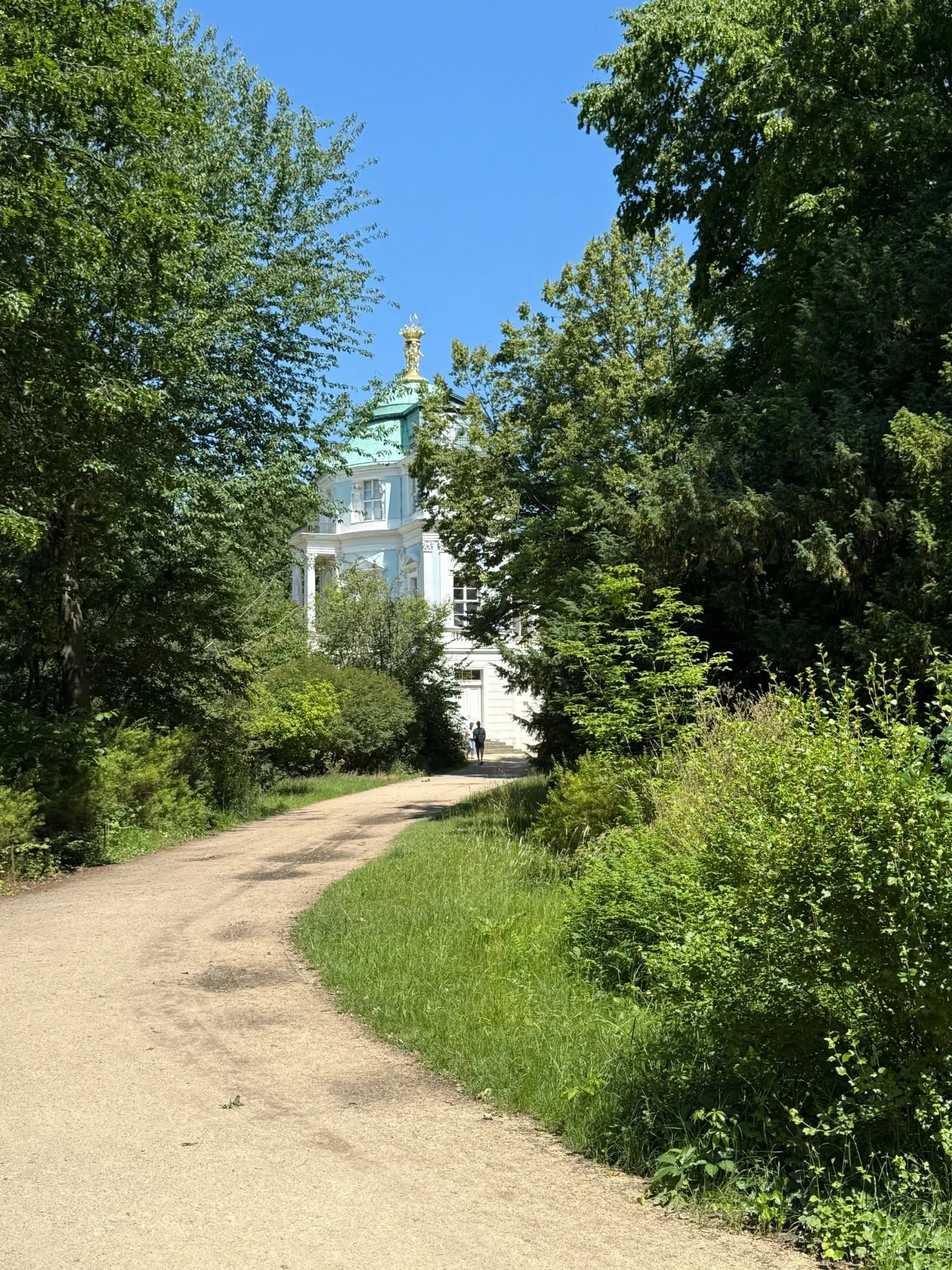 The pastel-blue Belvedere royal teahouse and viewing folly surrounded by trees in the gardens of Charlottenburg Palace