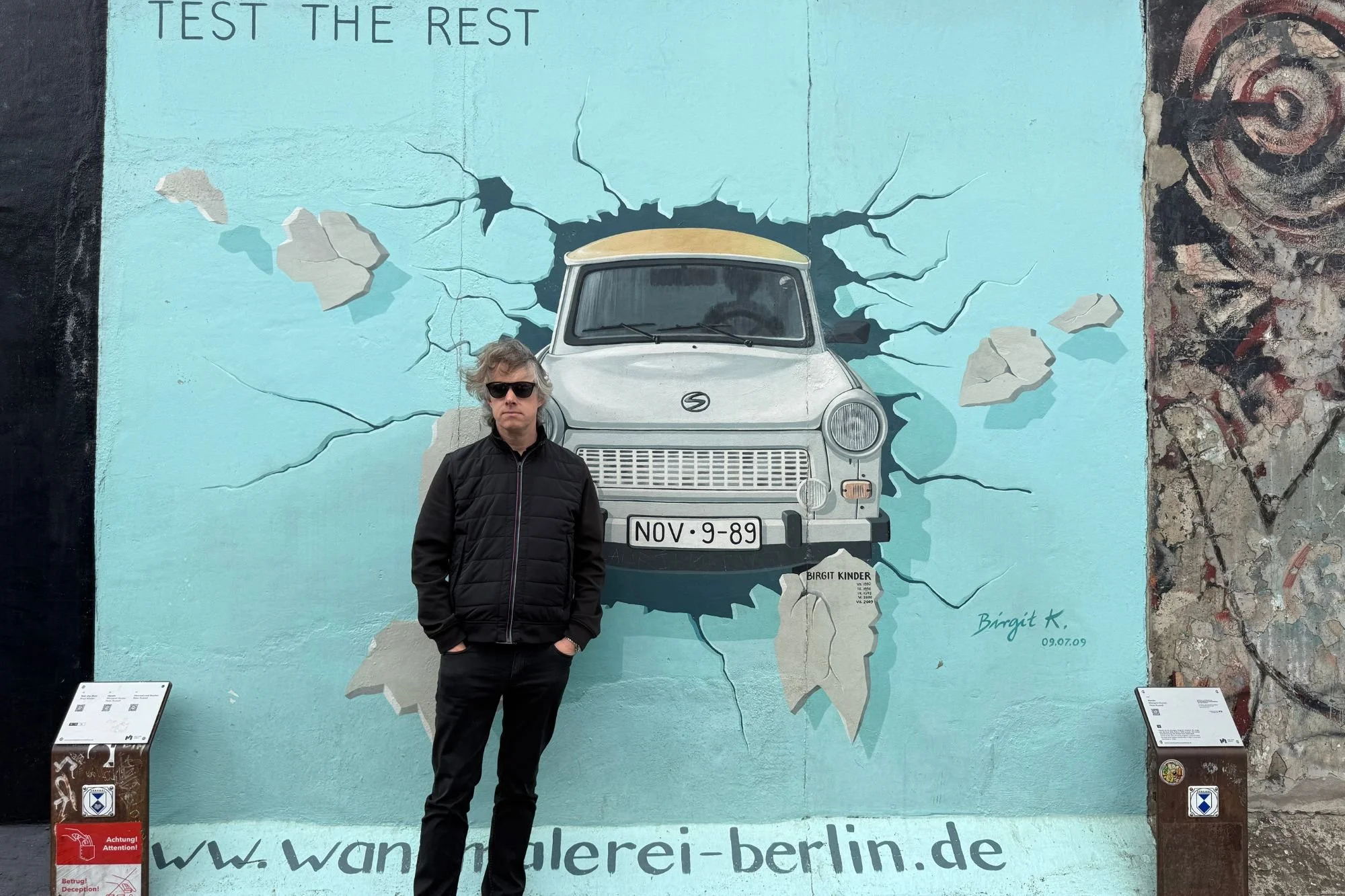 Jay standing in front of the Test the Rest Trabant artwork at Berlin's East Side Gallery