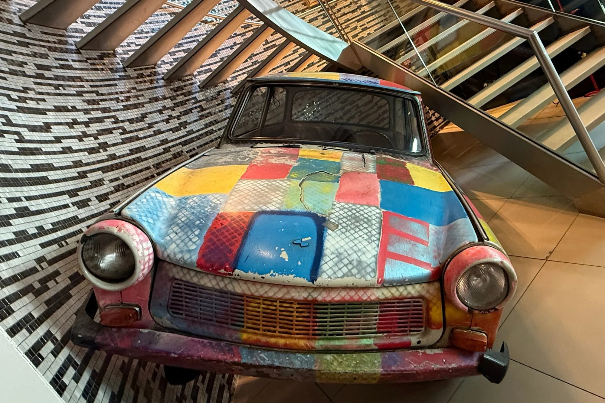 Front on photo of the patchwork painted U2 Trabant in Berlin's Hard Rock Cafe