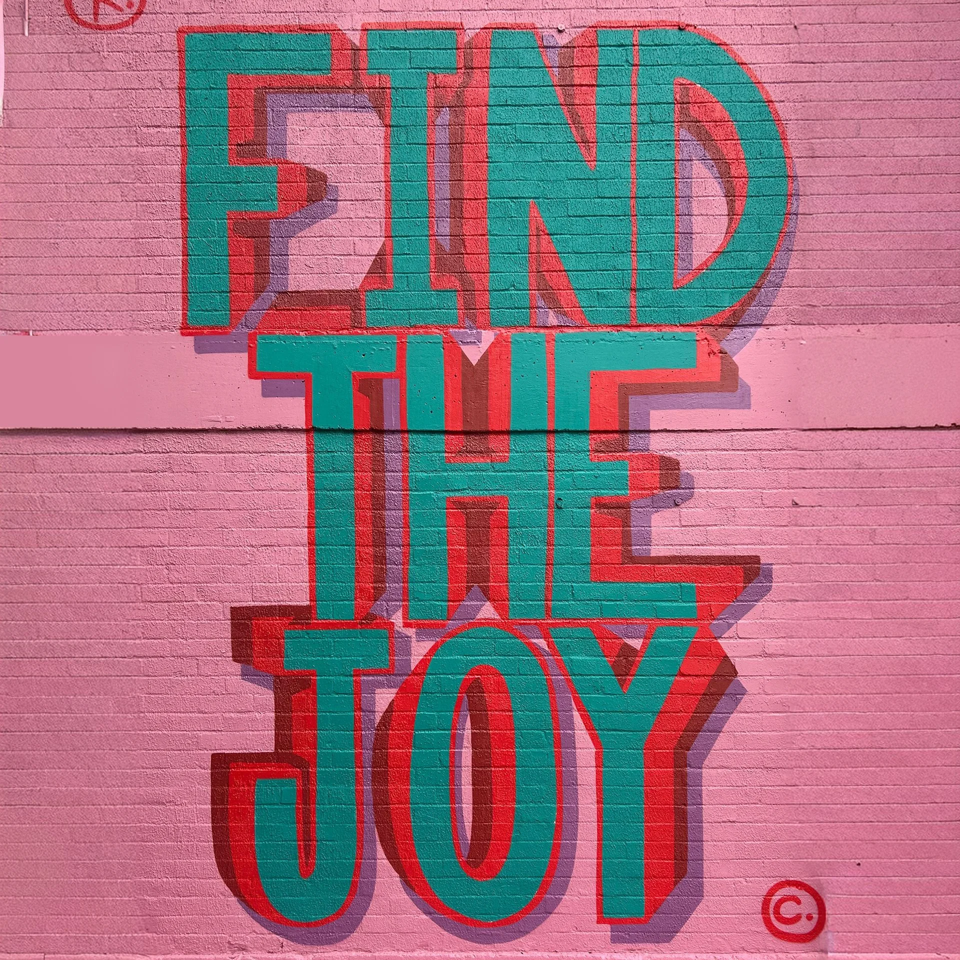 Graffitied wall, saying 'Find the Joy'
