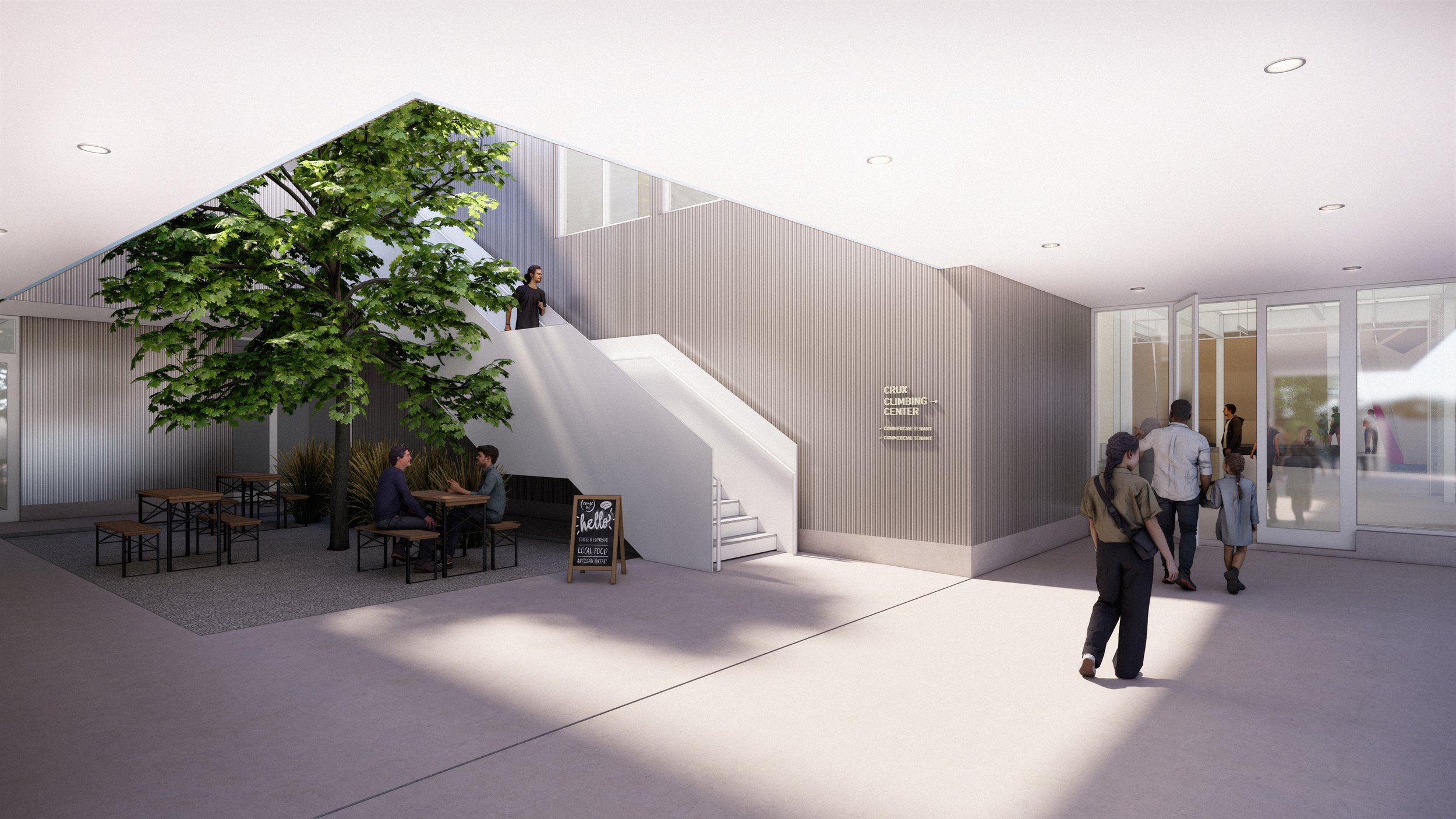 A carved courtyard under the building mass provides shade, seating, and a moment of pause at the entry—blurring the line between indoor threshold and outdoor gathering.