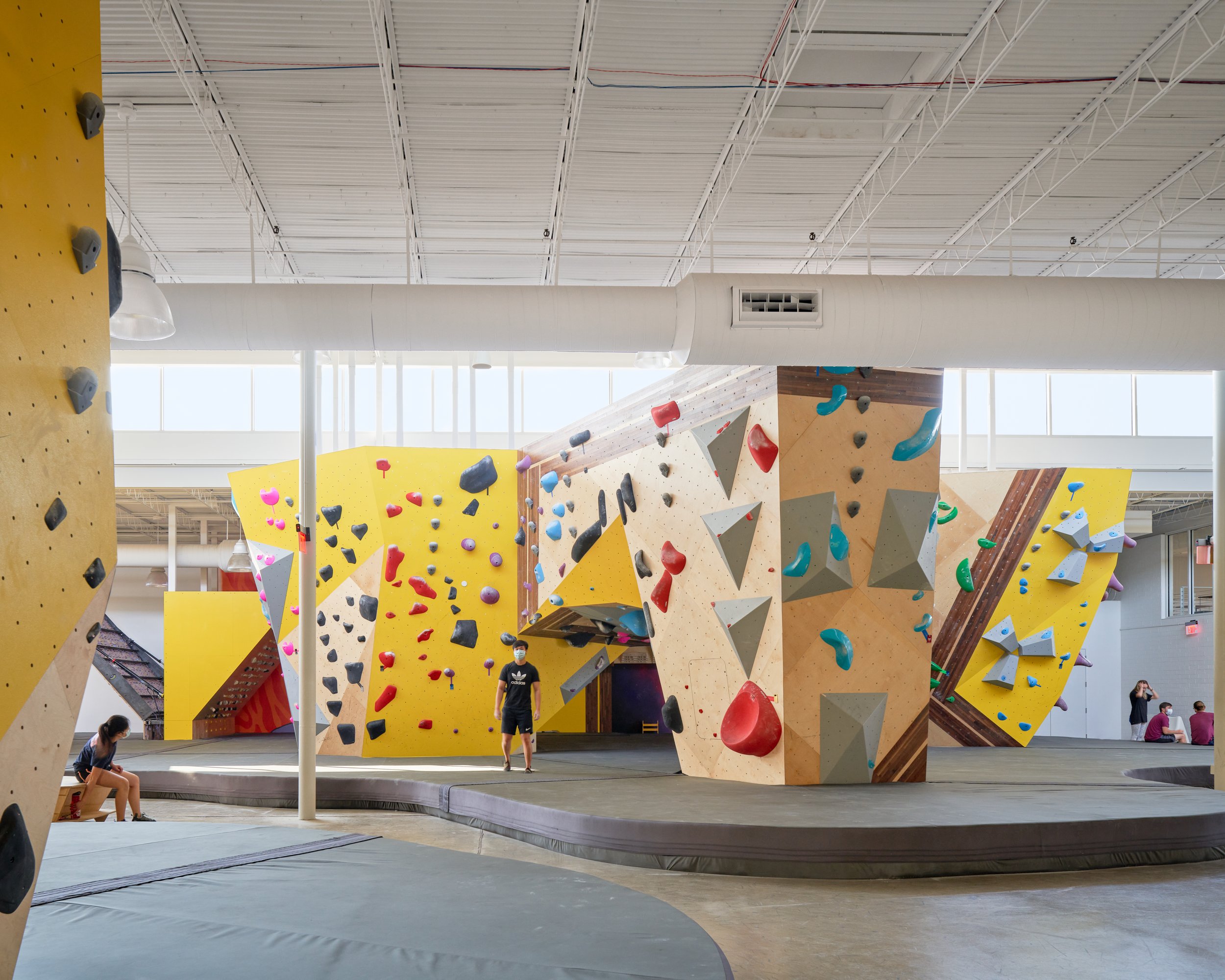 This view highlights the sculptural density of the central bouldering cluster. Material shifts, geometric volumes, and subtle circulation cues shape a playful yet efficient climbing environment.