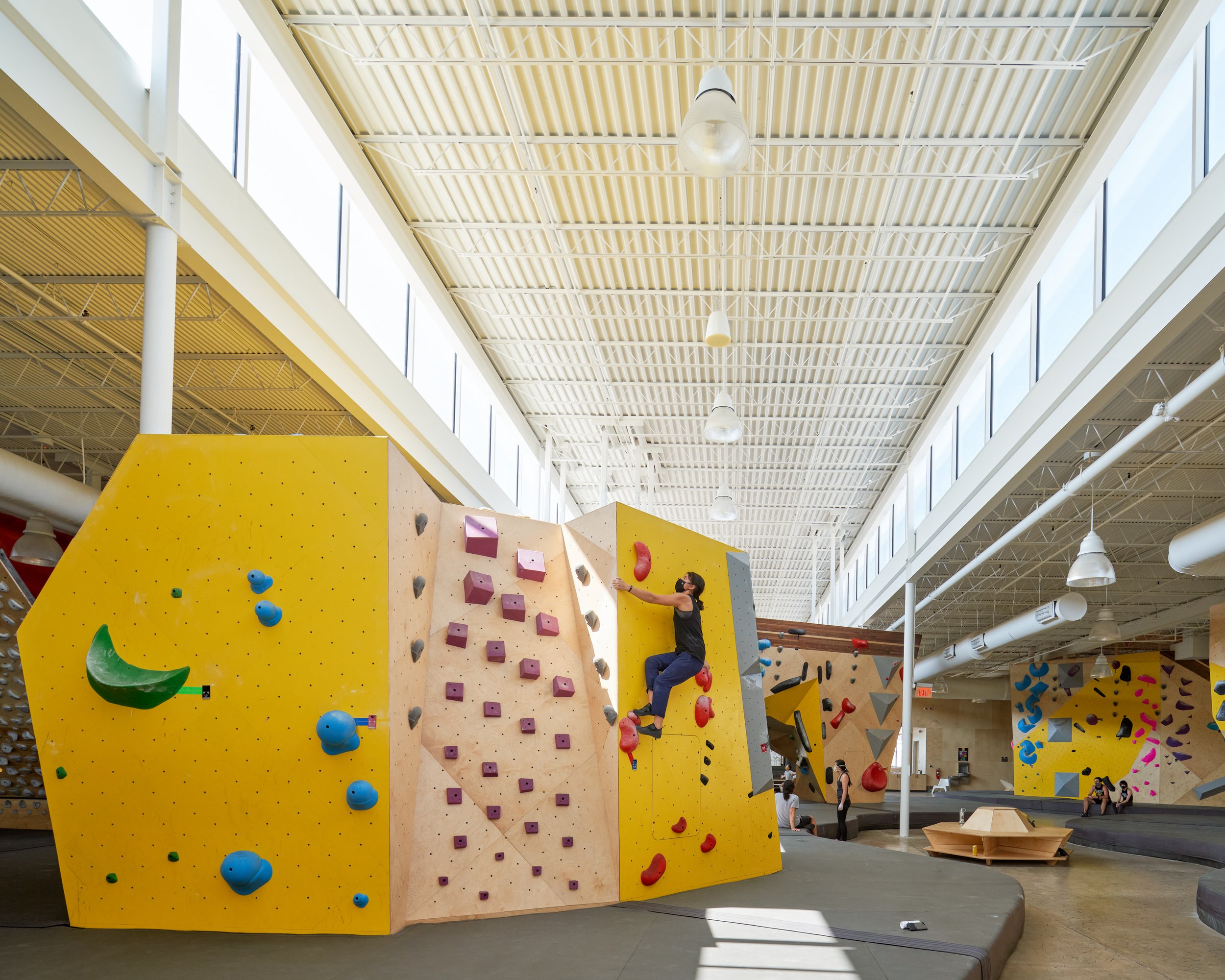 The wide clerestory band washes the space in daylight, while a lineup of distinct bouldering problems forms a dynamic, ever-shifting training landscape.