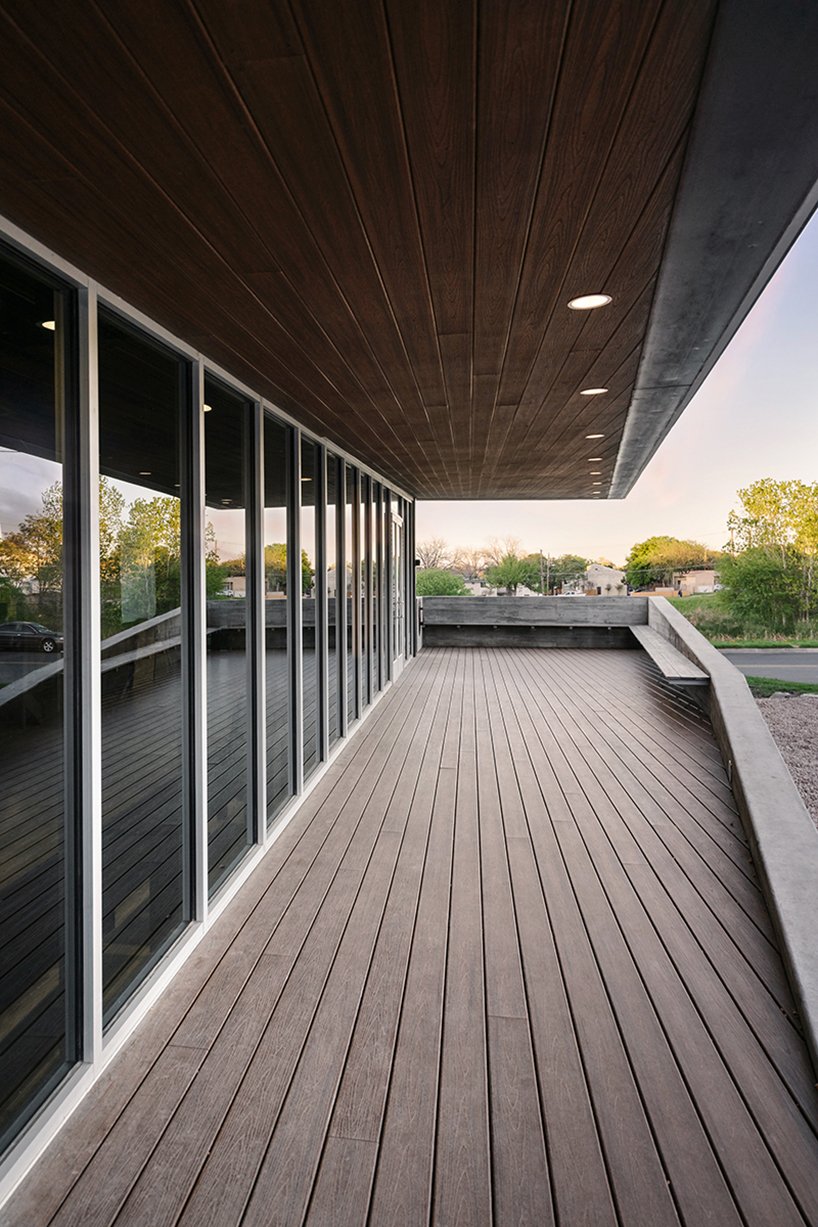 An covered entry under the yoga studio offers shielded views and shade, with board-formed concrete and dark wood detailing continuing the language of restraint and clarity.