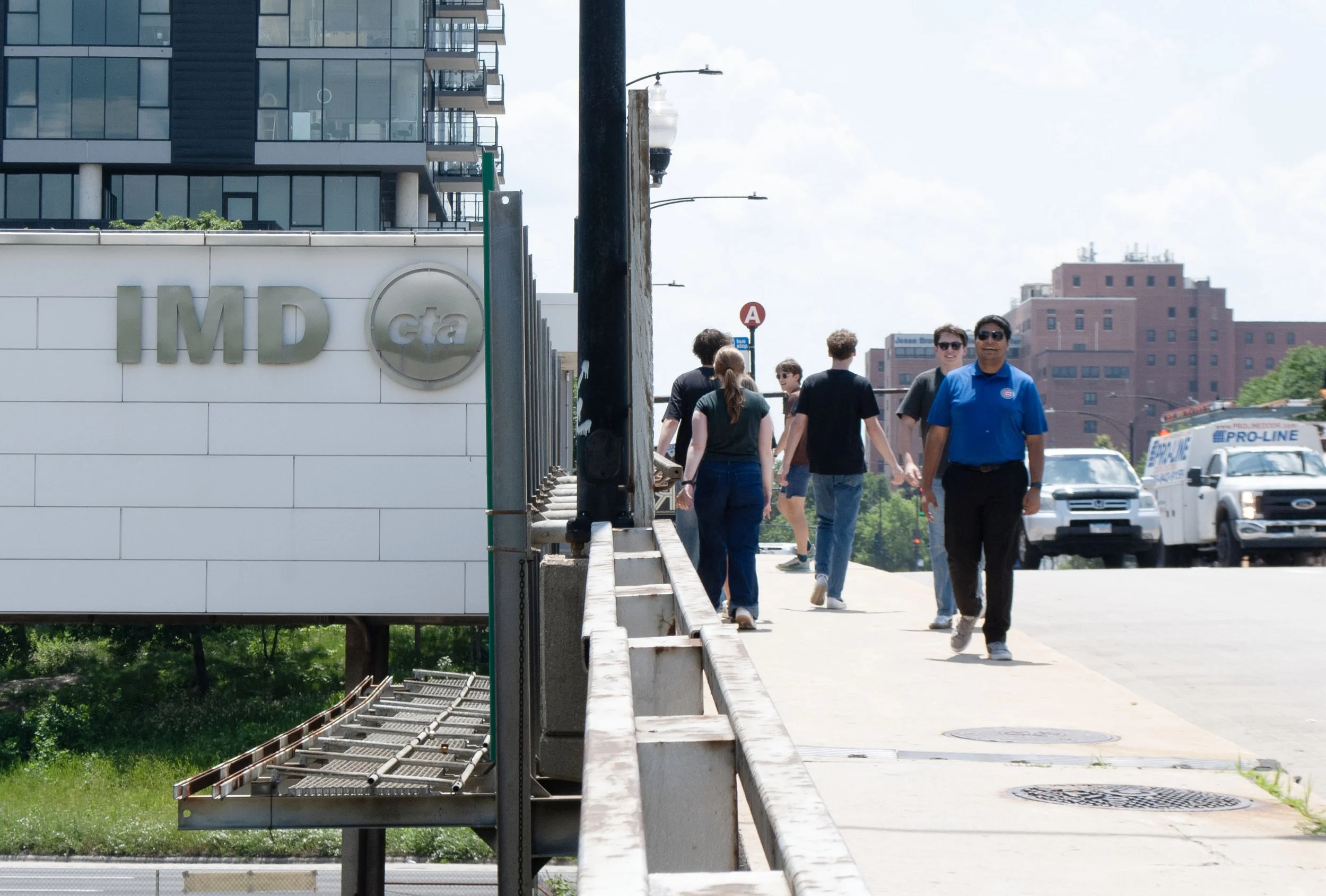Pedestrians cross the Damen Ave. bridge over I-290 in front of CTA’s Illinois Medical District station.