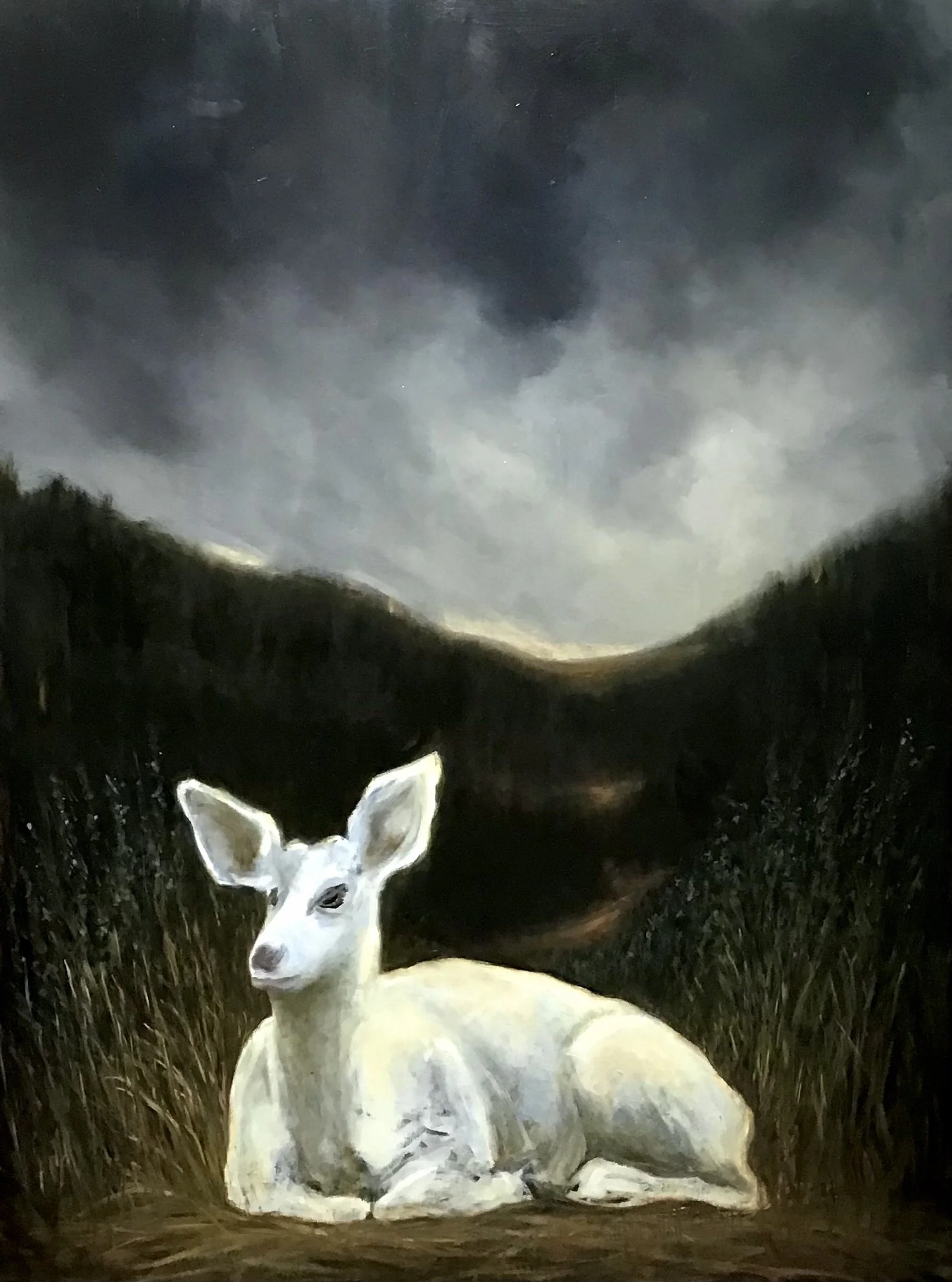 A white deer resting on the ground in a dark, hilly landscape under a cloudy, moonlit sky.
