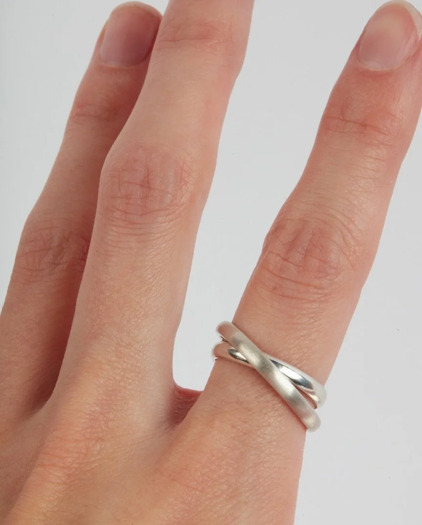 Kinetic elegance in motion
Two interlocking bands, joined by a hidden axle, move with every gesture. The matte ring gently tilts, revealing flashes of the polished band beneath &mdash; a quiet rhythm of balance and contrast.
Curious how it&rsquo;s ma