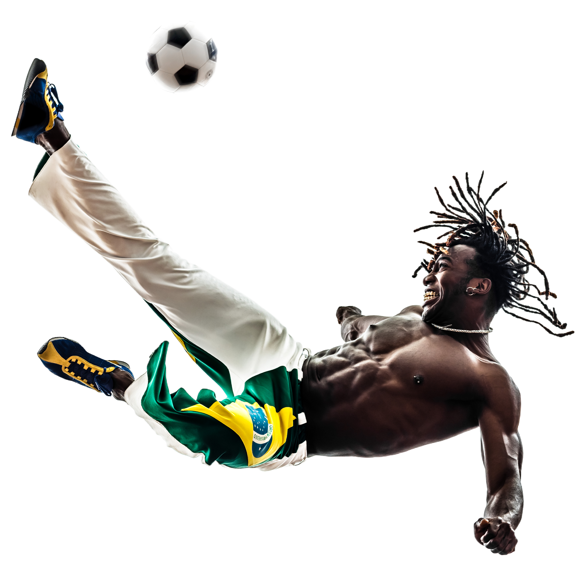 A shirtless man with dreadlocks and a Brazilian flag shorts performing a high kick with a soccer ball in midair