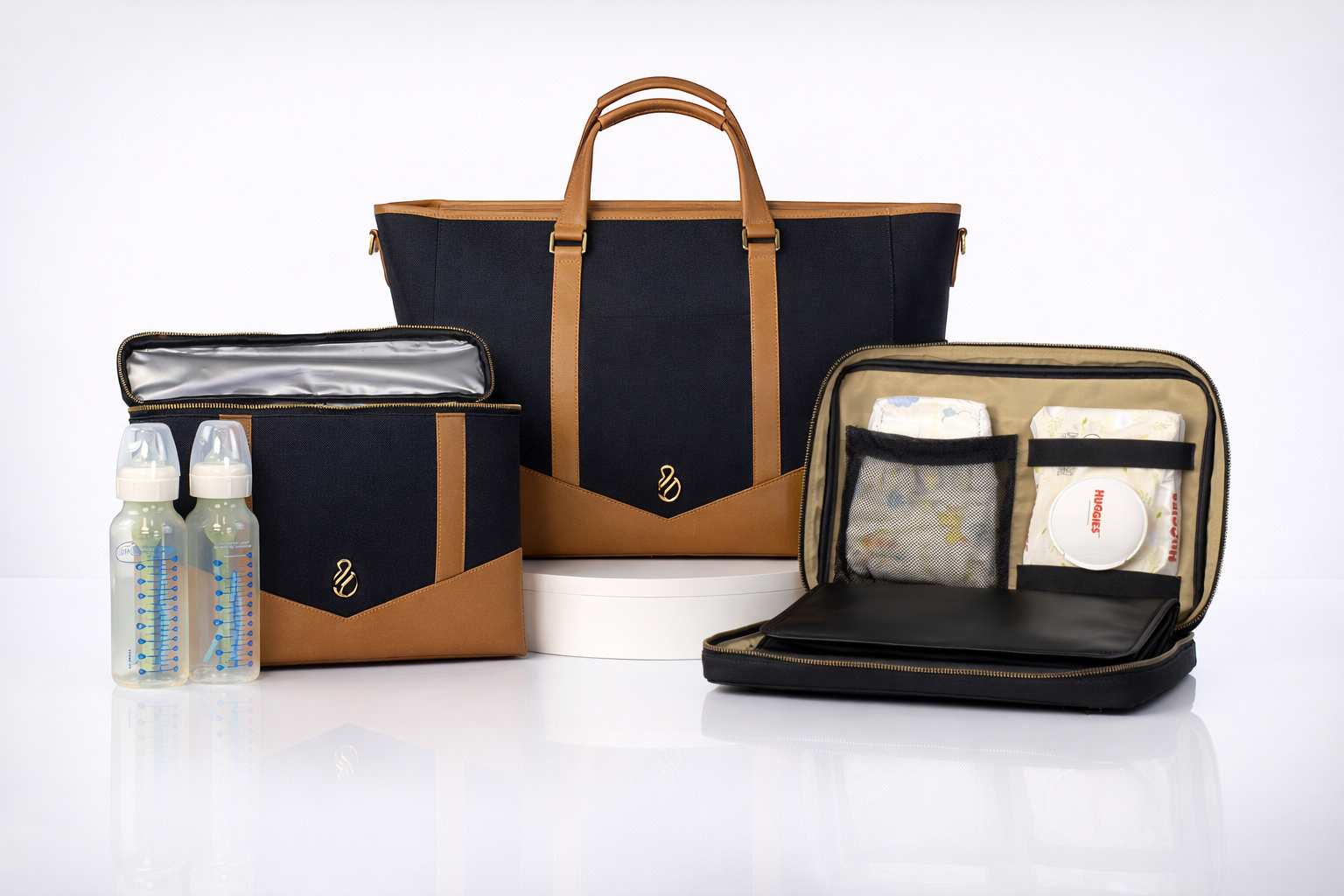 The Little Hauler modular parenting tote with interchangeable pods attached, shown in black coated canvas with leather trim