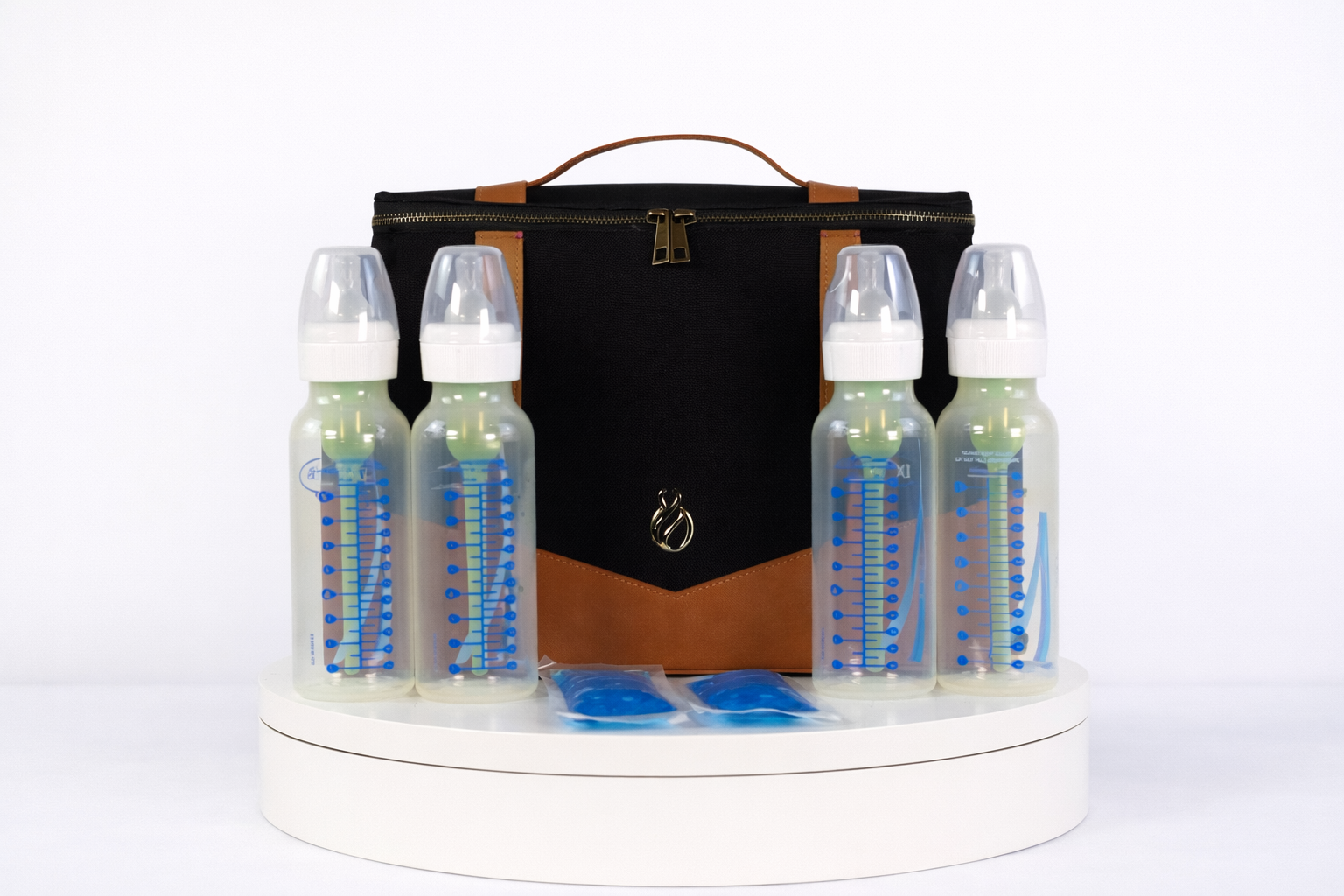 The Little Hauler Insulated Pod, part of the modular parenting system, with baby bottles and ice packs showcasing it's use as a bottle bag.