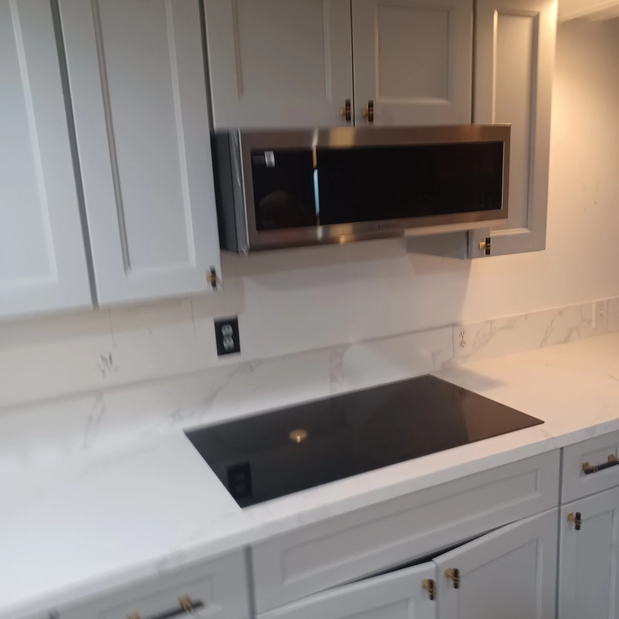Kitchen with white cabinets and stainless steel microwave oven.