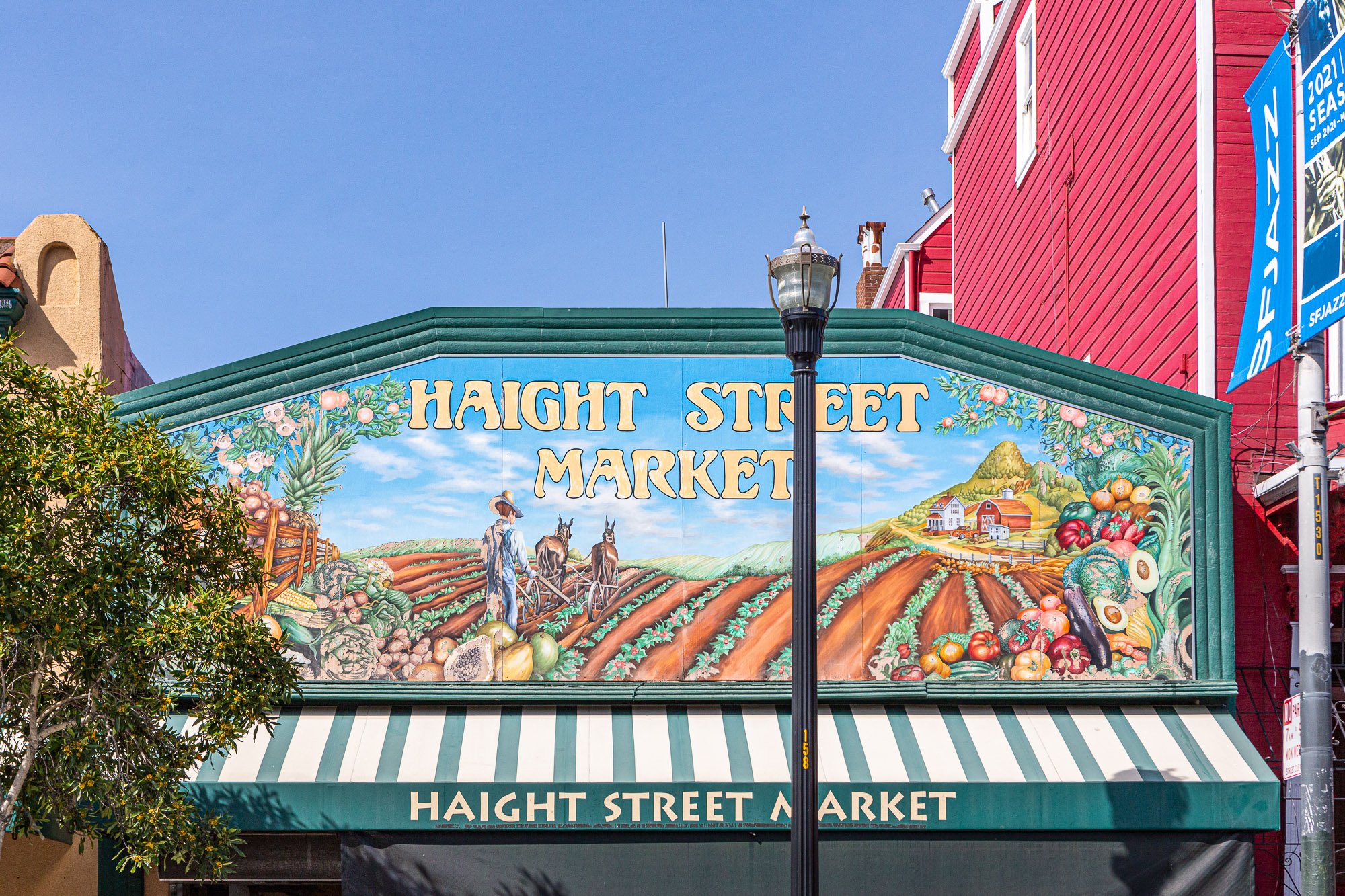 Haight Street Market entrance with vibrant mural depicting farm scene and produce.
