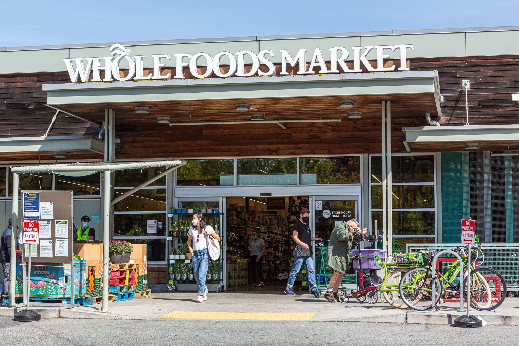 Exterior of Whole Foods Market store with people and bicycles.
