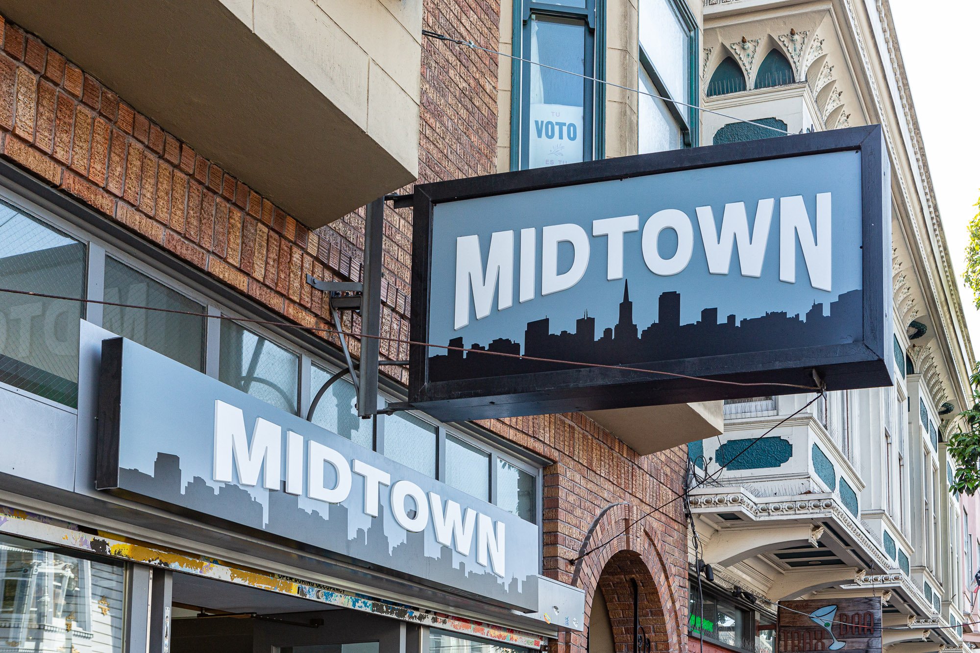 Storefront with "Midtown" sign and city skyline graphic