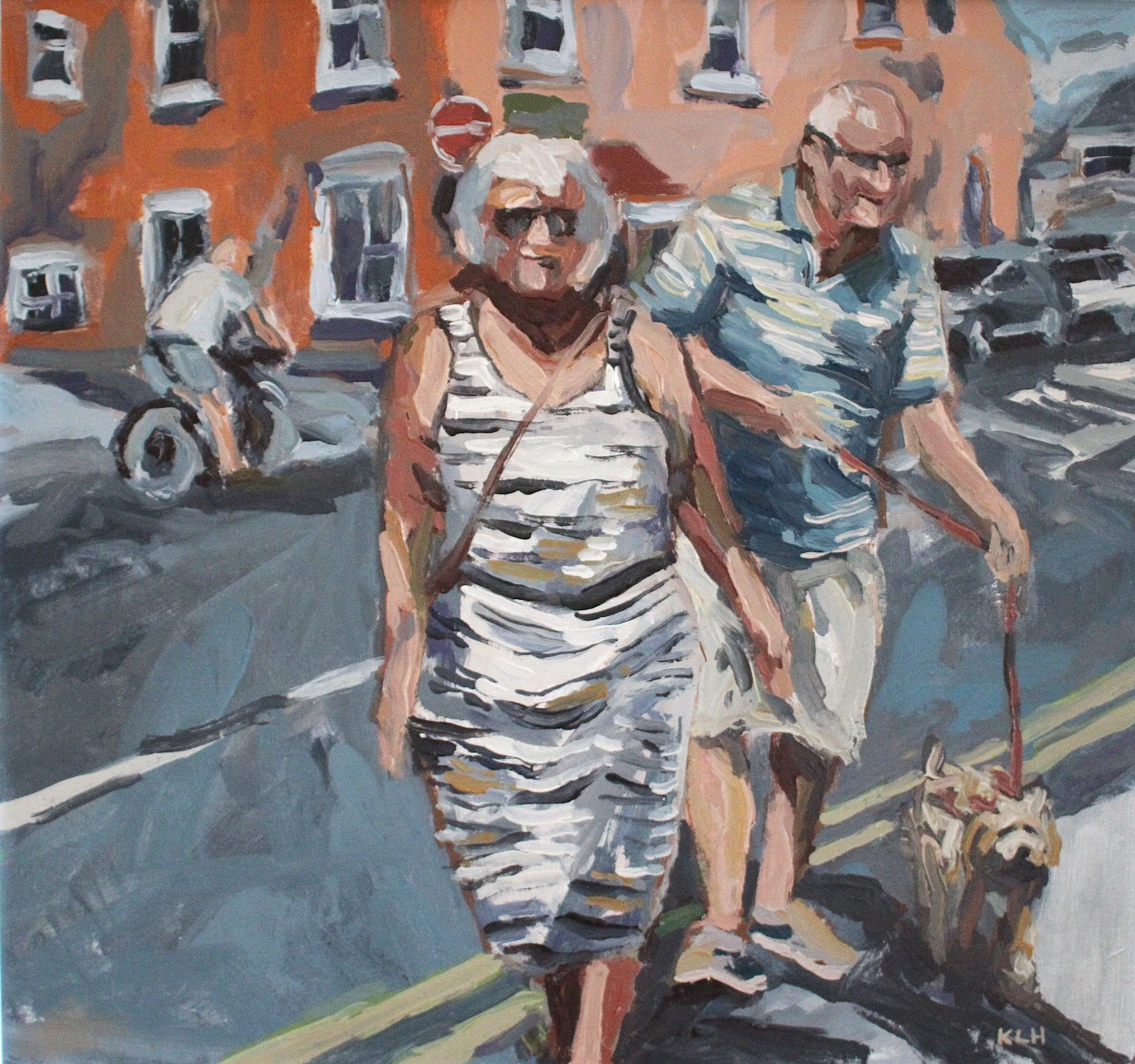 Two elderly women walking dogs on a city street on a sunny day, with buildings and a cyclist in the background.