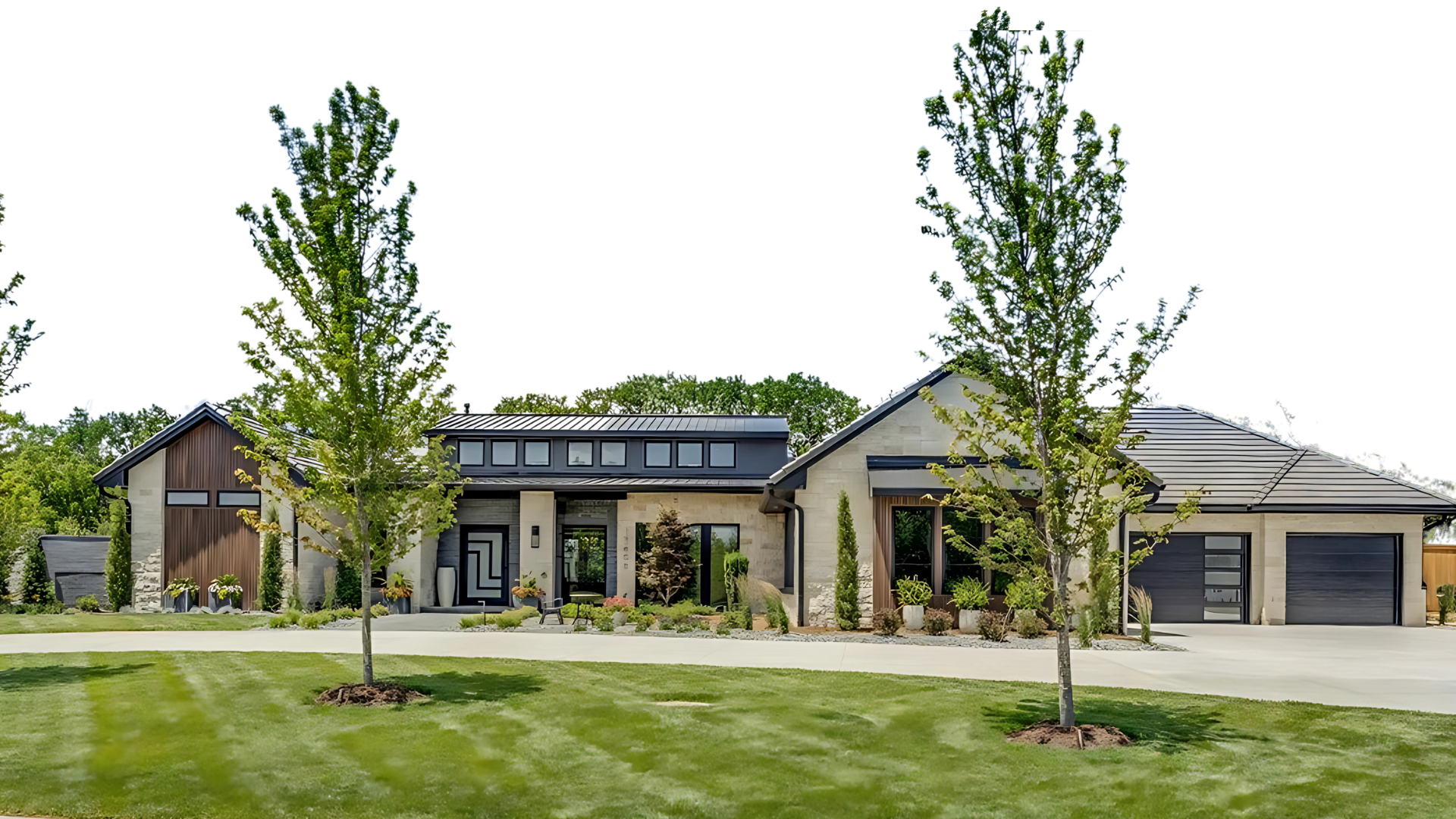 Modern house with a manicured lawn, trees, and a driveway