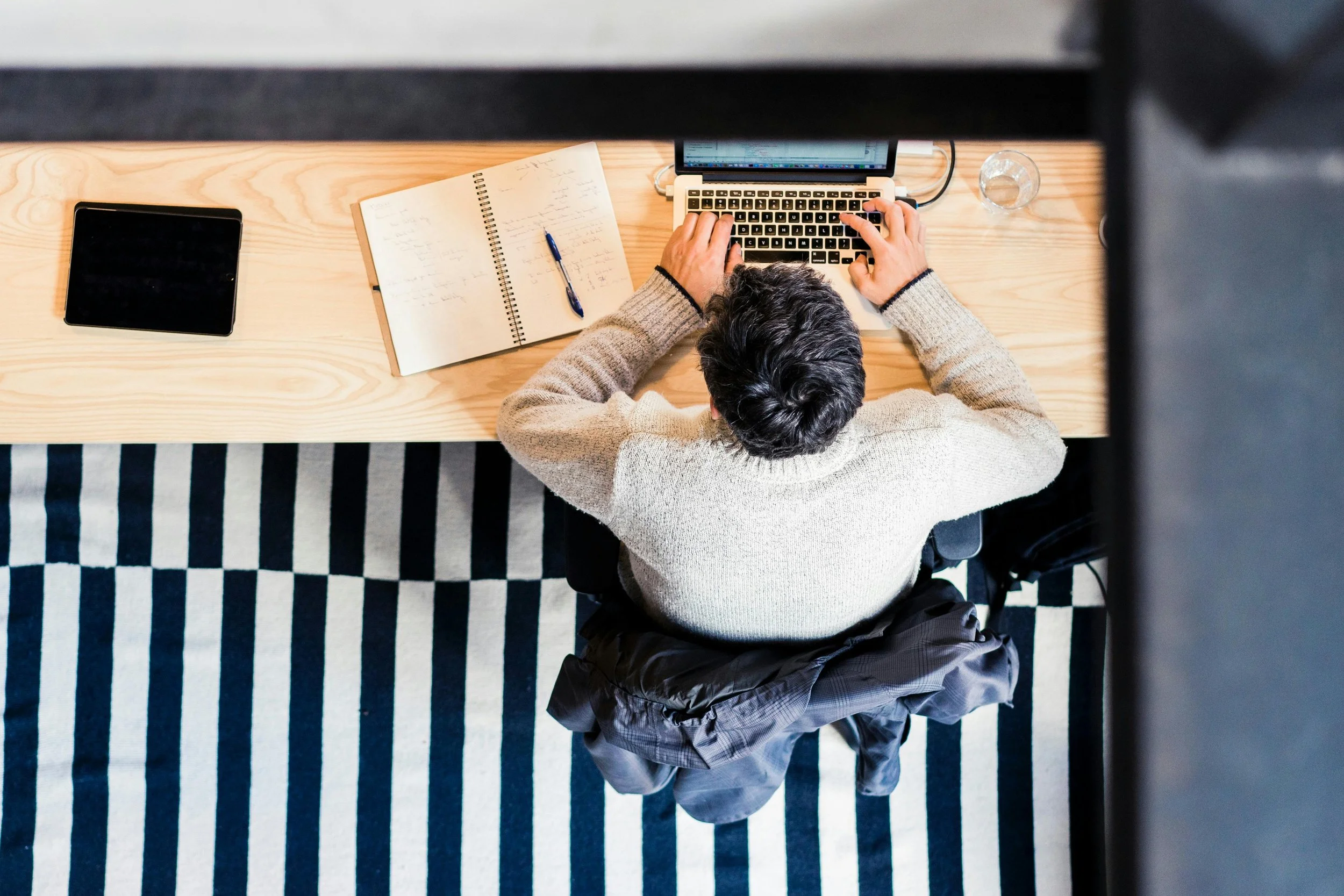 Photo of man from above sitting and working on a computer