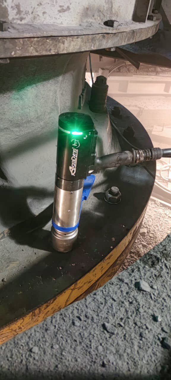 close up of the Acradyne DC Nutrunner bolting a wind tower hub with a green light on showing the job is complete