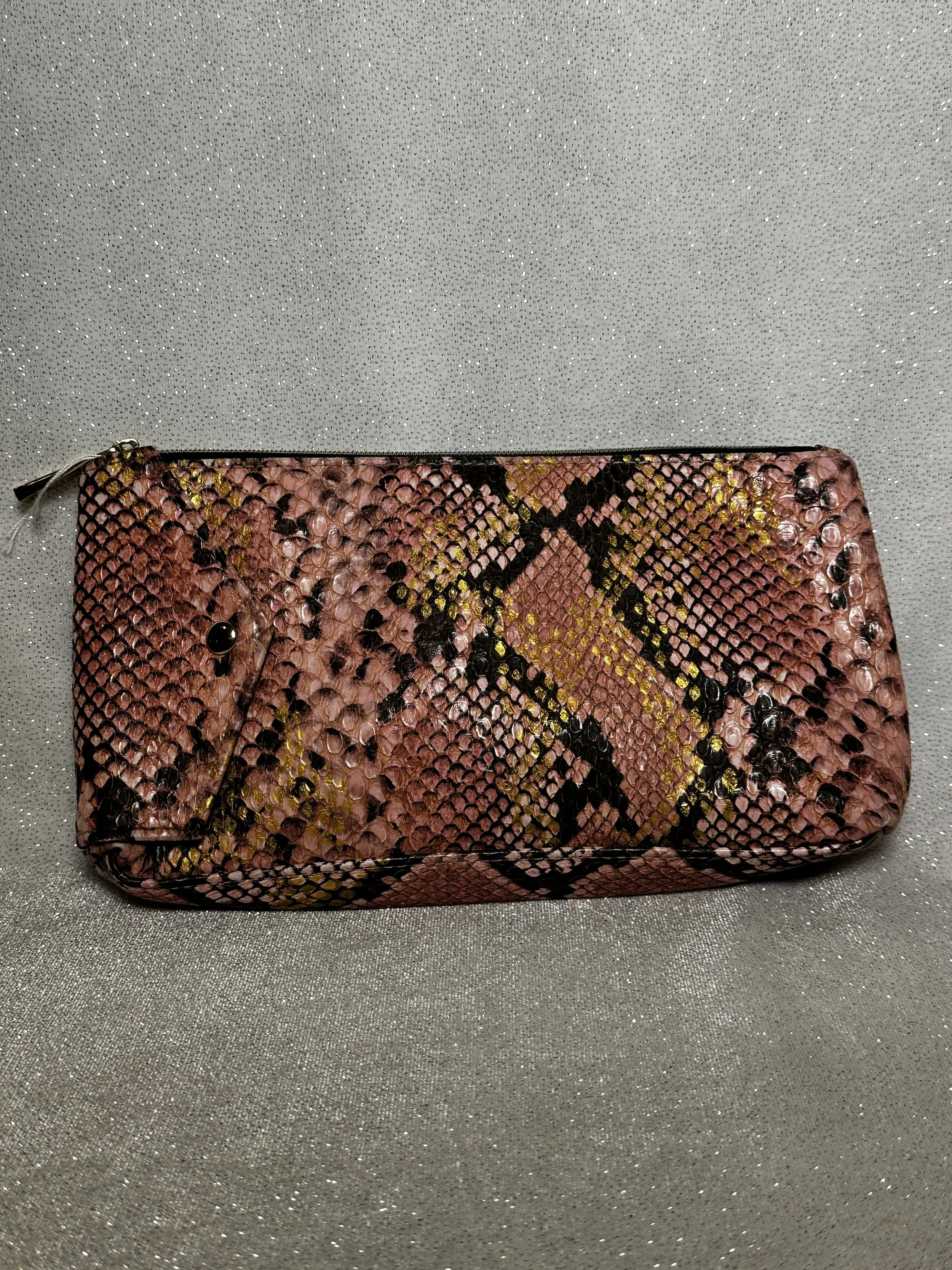 Pink and black snakeskin-patterned clutch purse with a zip closure, placed on a sparkly silver surface.