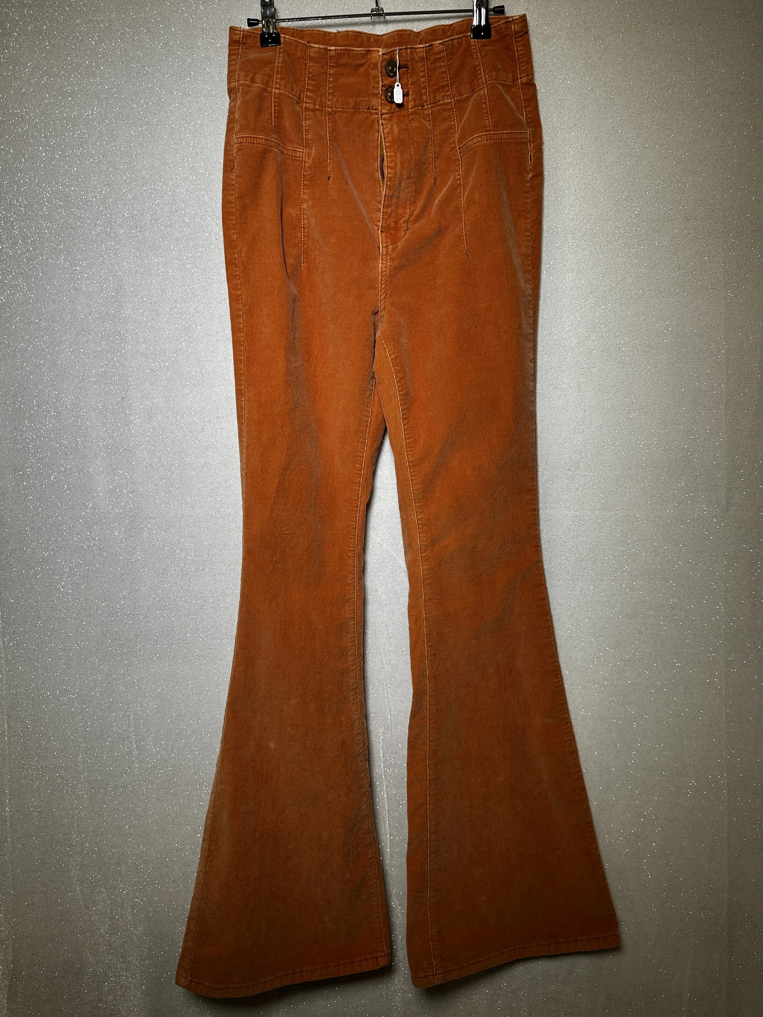 Pair of brown corduroy pants hanging on a wall