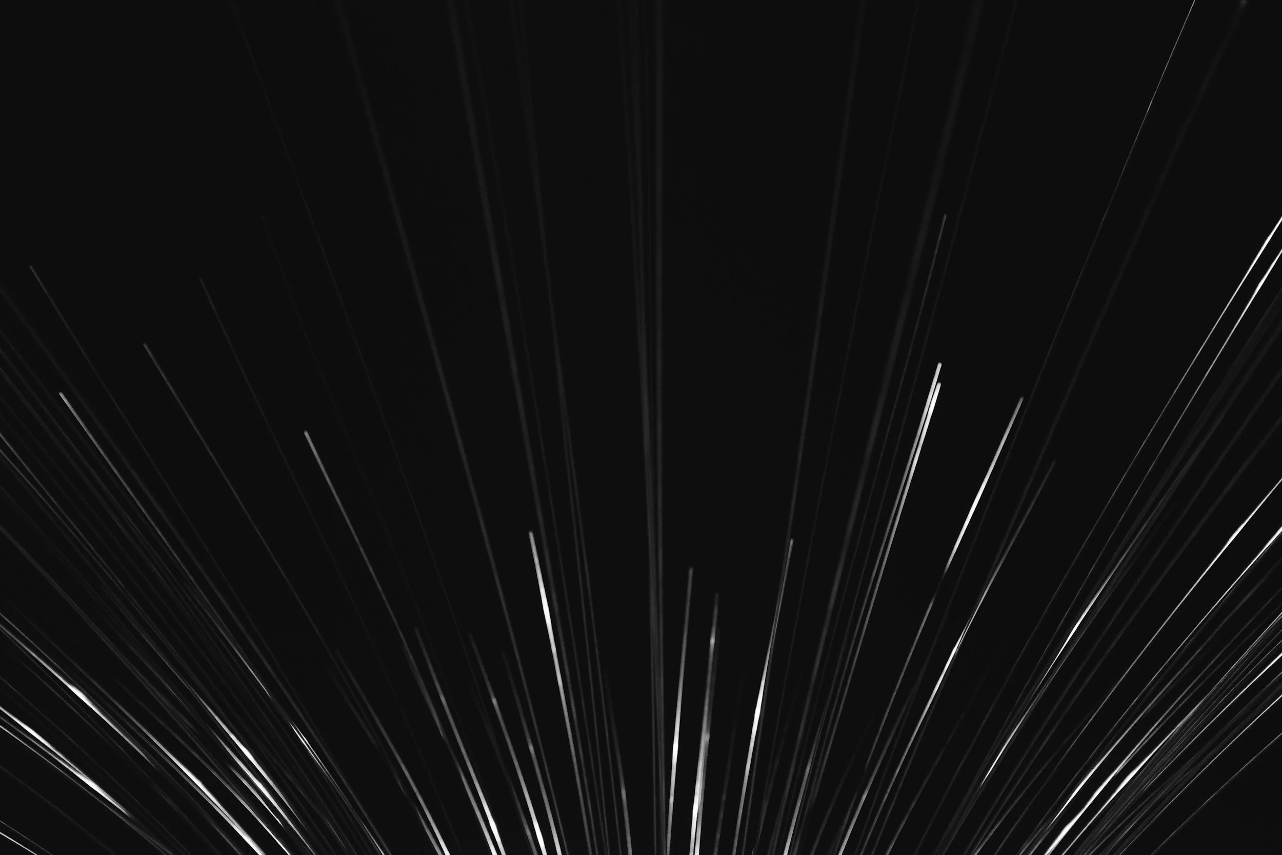 Black background with white linear streaks radiating outward, creating a dynamic motion effect.