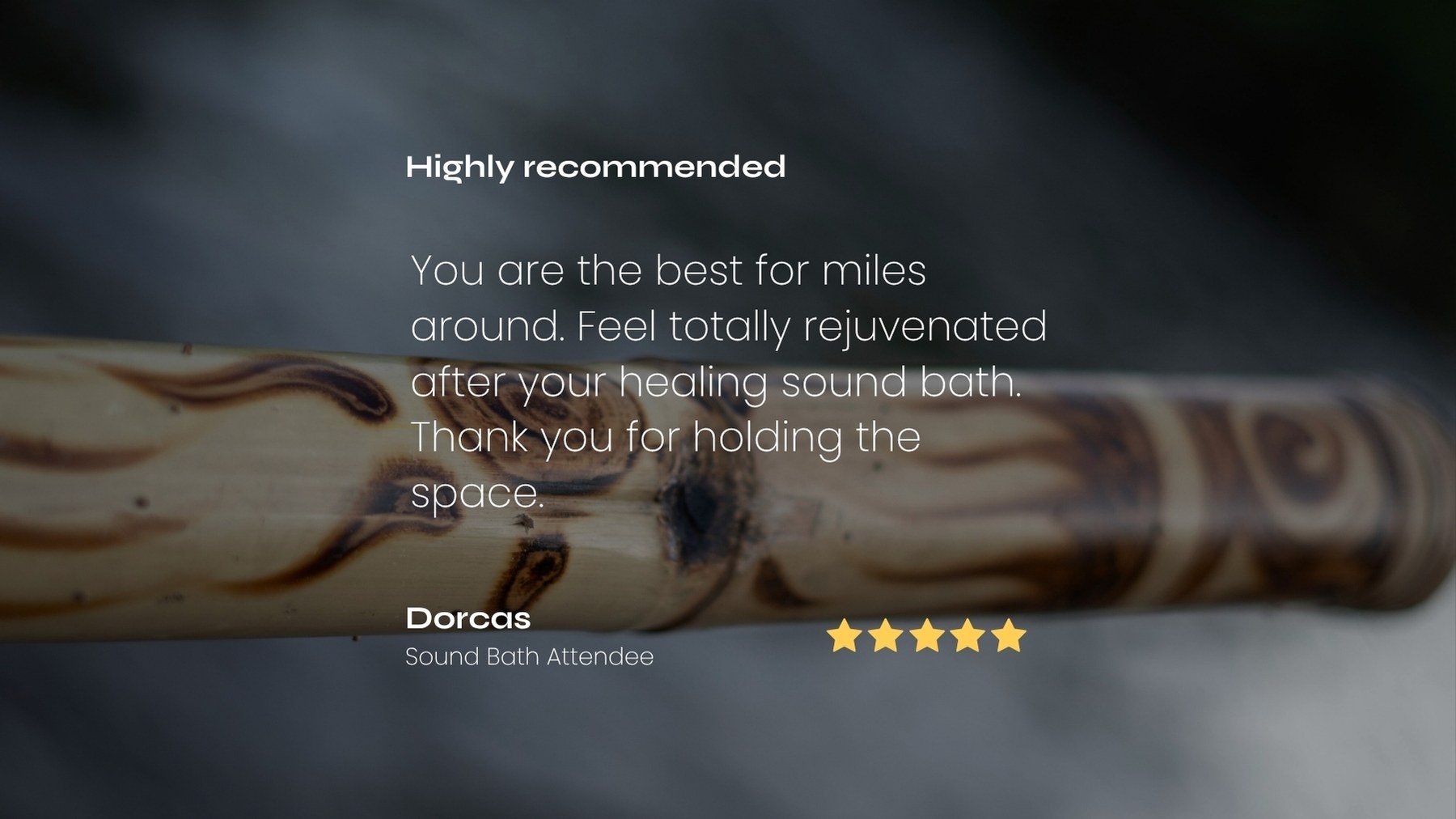 A wooden rain stick with tribal patterns, with overlaid testimonial text praising its rejuvenating effects after a sound bath and a five-star rating below.