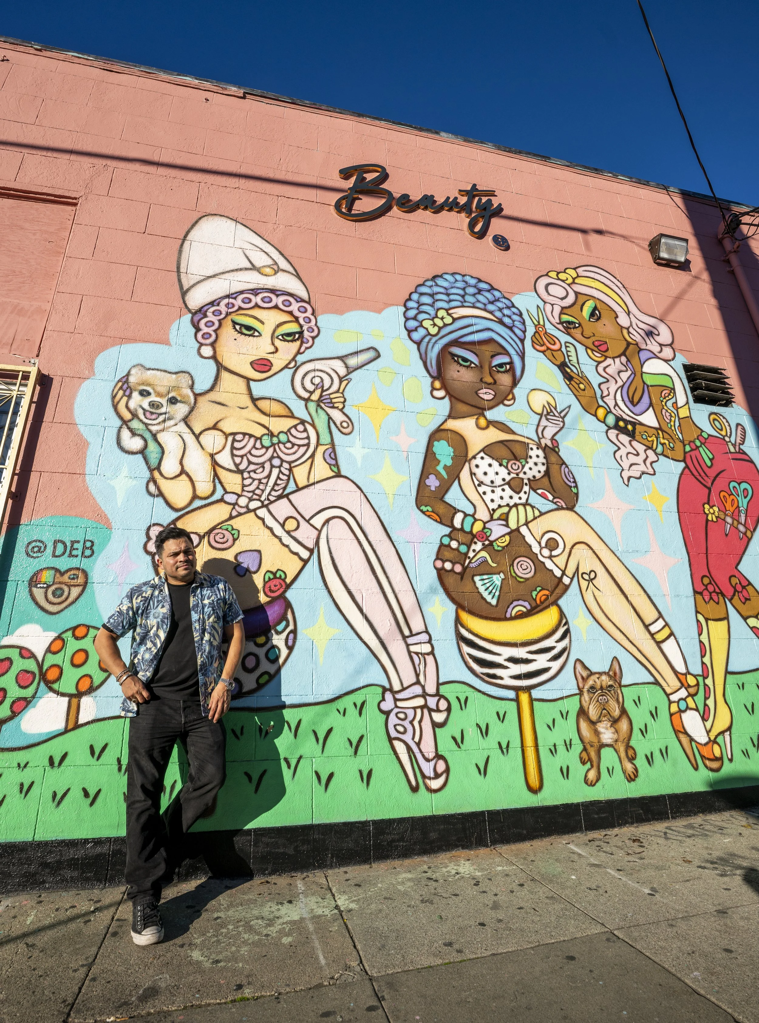 mural that says beauty bar with man posing in front of it