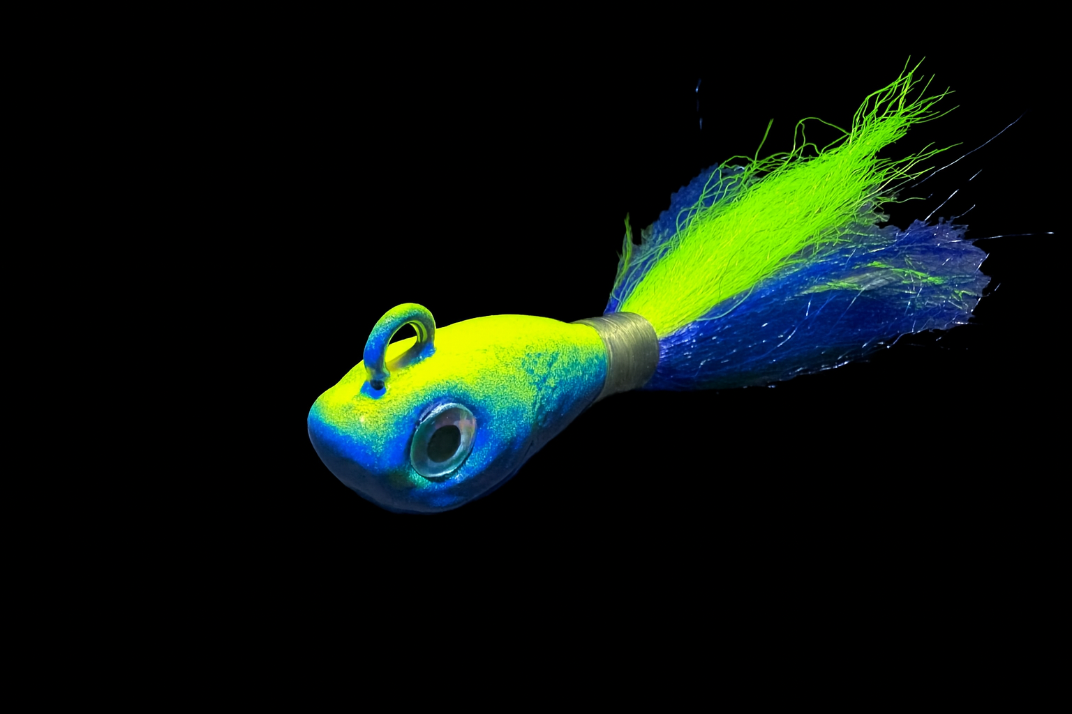 Colorful fishing lure with a blue, green, and yellow head and neon yellow and blue skirt on a black background.